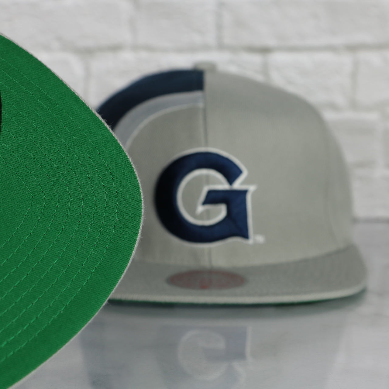 green under visor on the Georgetown University Hoyas Retroline Logo Outline Vintage Snapback Hat | Mitchell and Ness Hoyas Snap Cap