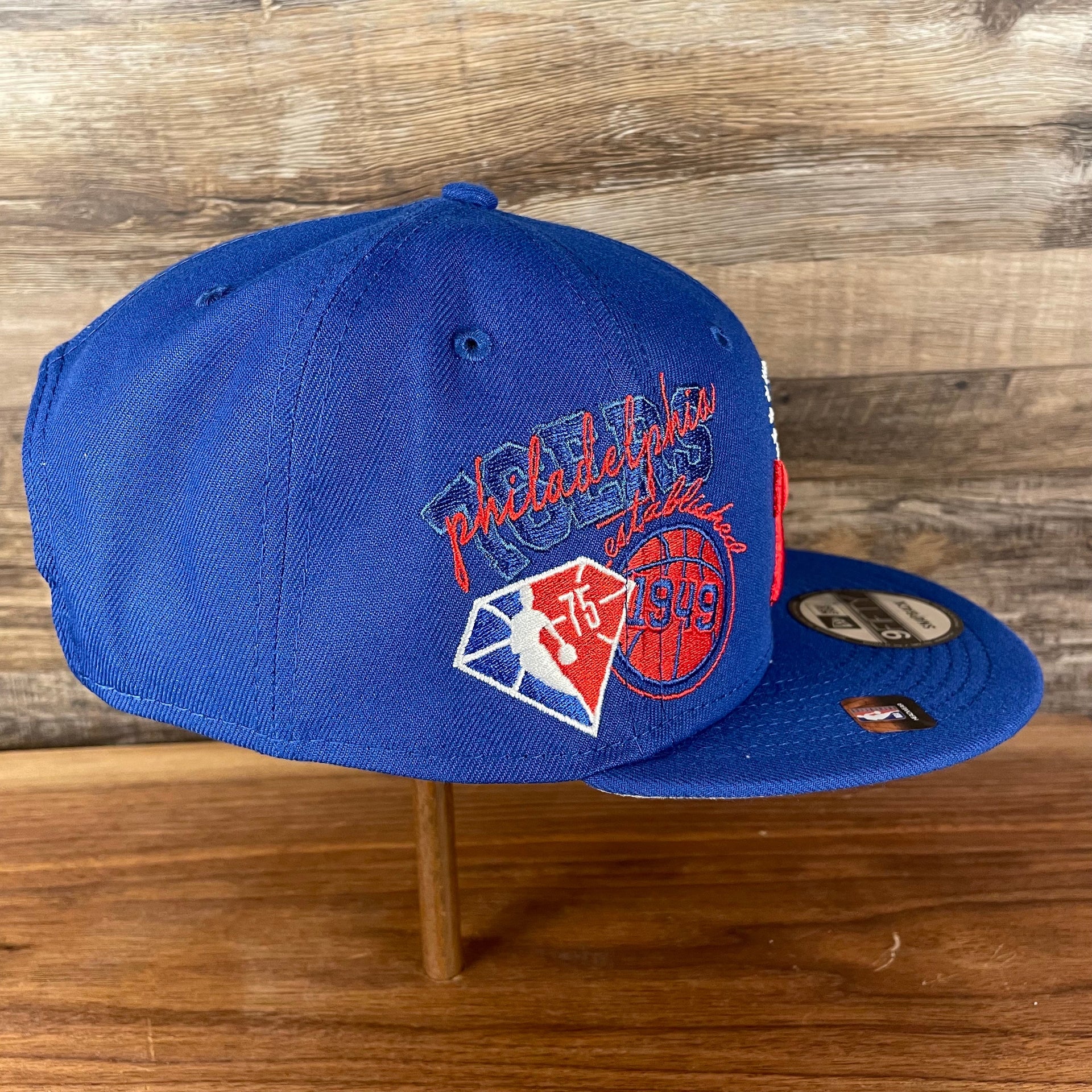 Wearer's right of the Philadelphia 76ers NBA 75th Anniversary Side Patch Gray Bottom Royal 9Fifty Snapback Hat | Back Half