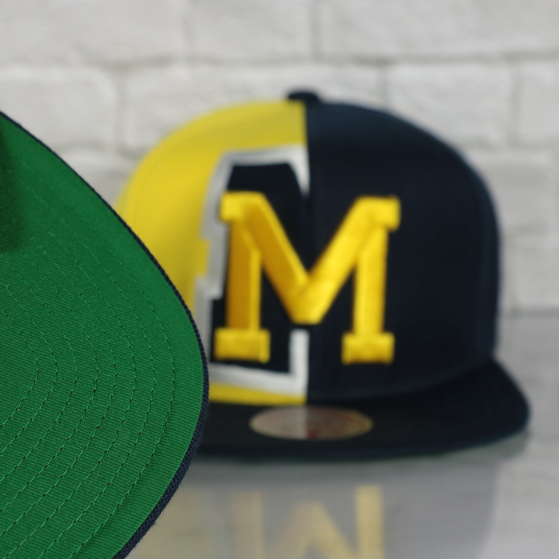green under visor on the University of Michigan Wolverines Retroline Logo Outline Vintage Snapback Hat | Mitchell and Ness Wolverines Snap Cap