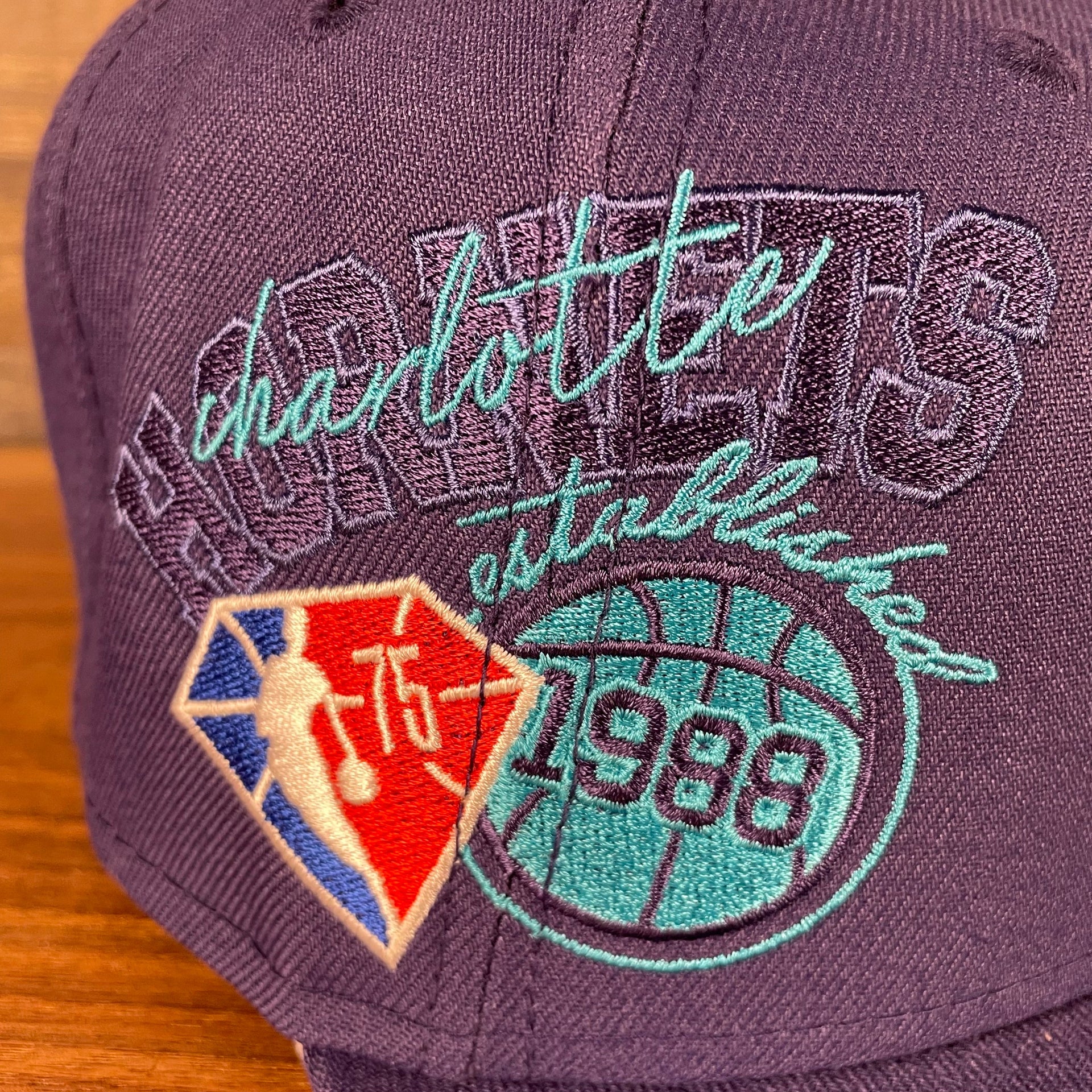 Close up of the side patch on the Charlotte Hornets NBA 75th Anniversary Side Patch Gray Bottom Purple 9Fifty Snapback Hat | Back Half