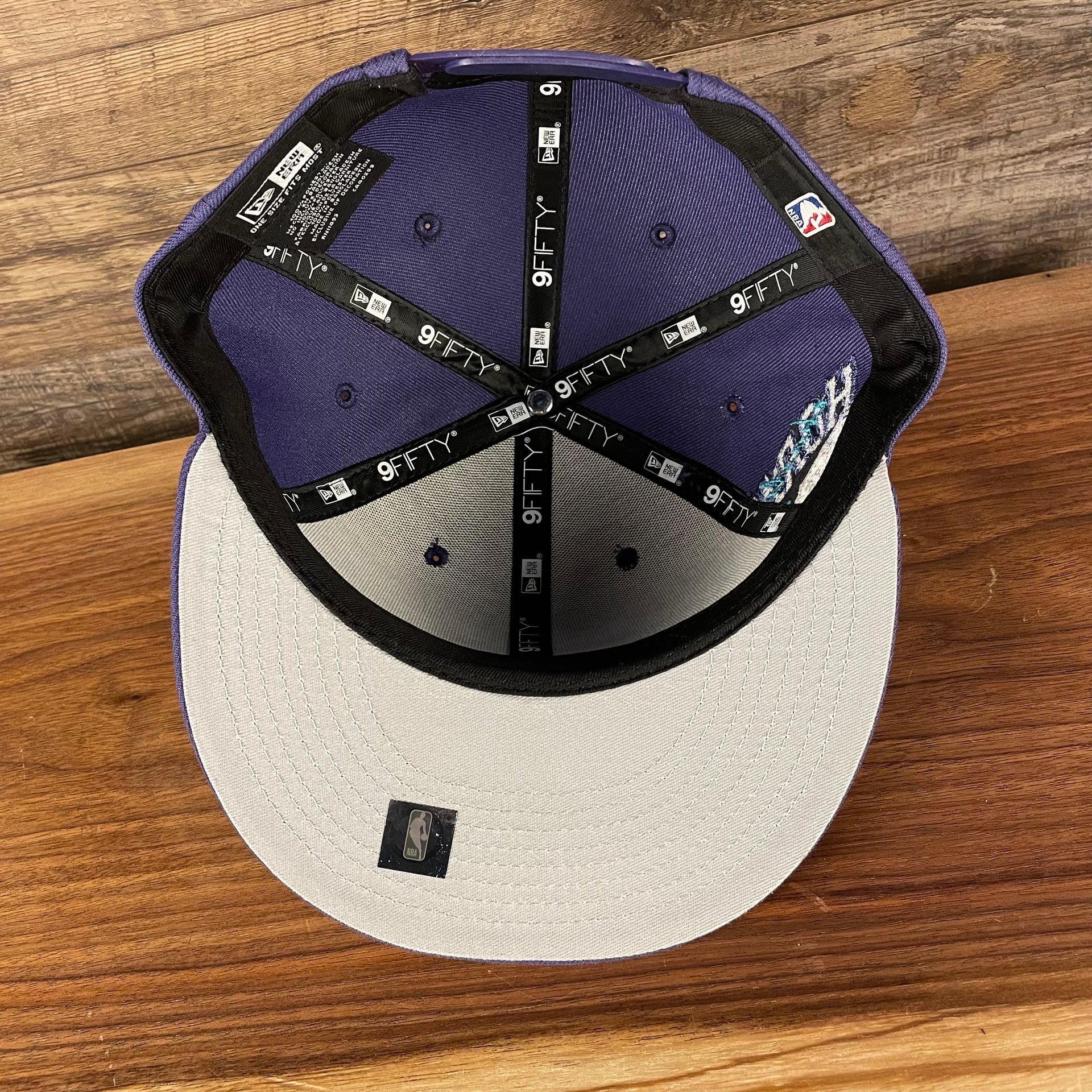 Gray under visor of the Charlotte Hornets NBA 75th Anniversary Side Patch Gray Bottom Purple 9Fifty Snapback Hat | Back Half