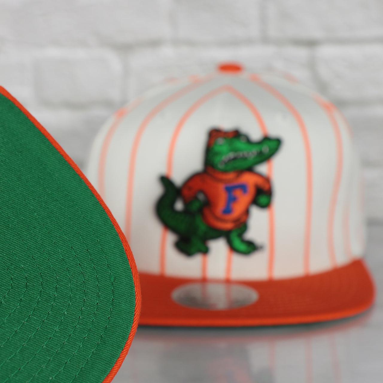 green under visor on the University of Florida Gators Vintage Pinstripe Baseball Hat | Retro Mitchell and Ness White Pinstripe Snapback Hat