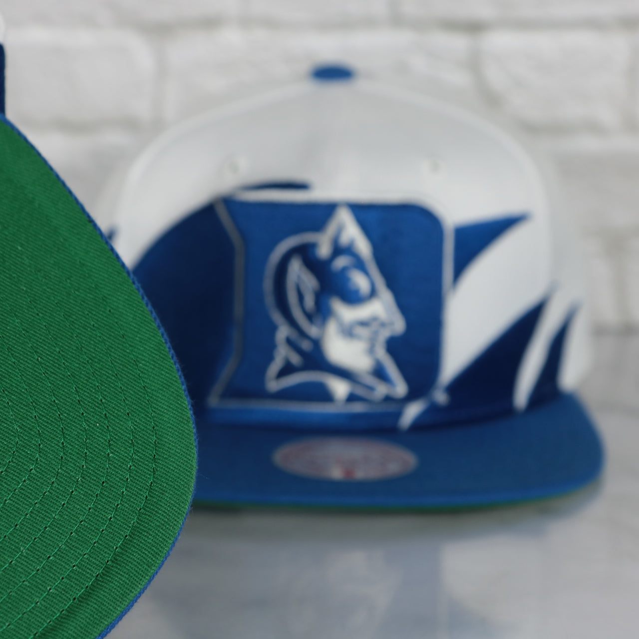 green under visor on the Duke University Blue Devils Vintage Retro Sharktooth Mitchell and Ness Snapback Hat | Blue/White