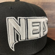 Close up of Nets lettering Brooklyn Nets NBA 75th Anniversary 2012 Side Patch Gray Bottom Black 9Fifty Snapback Hat | City Edition