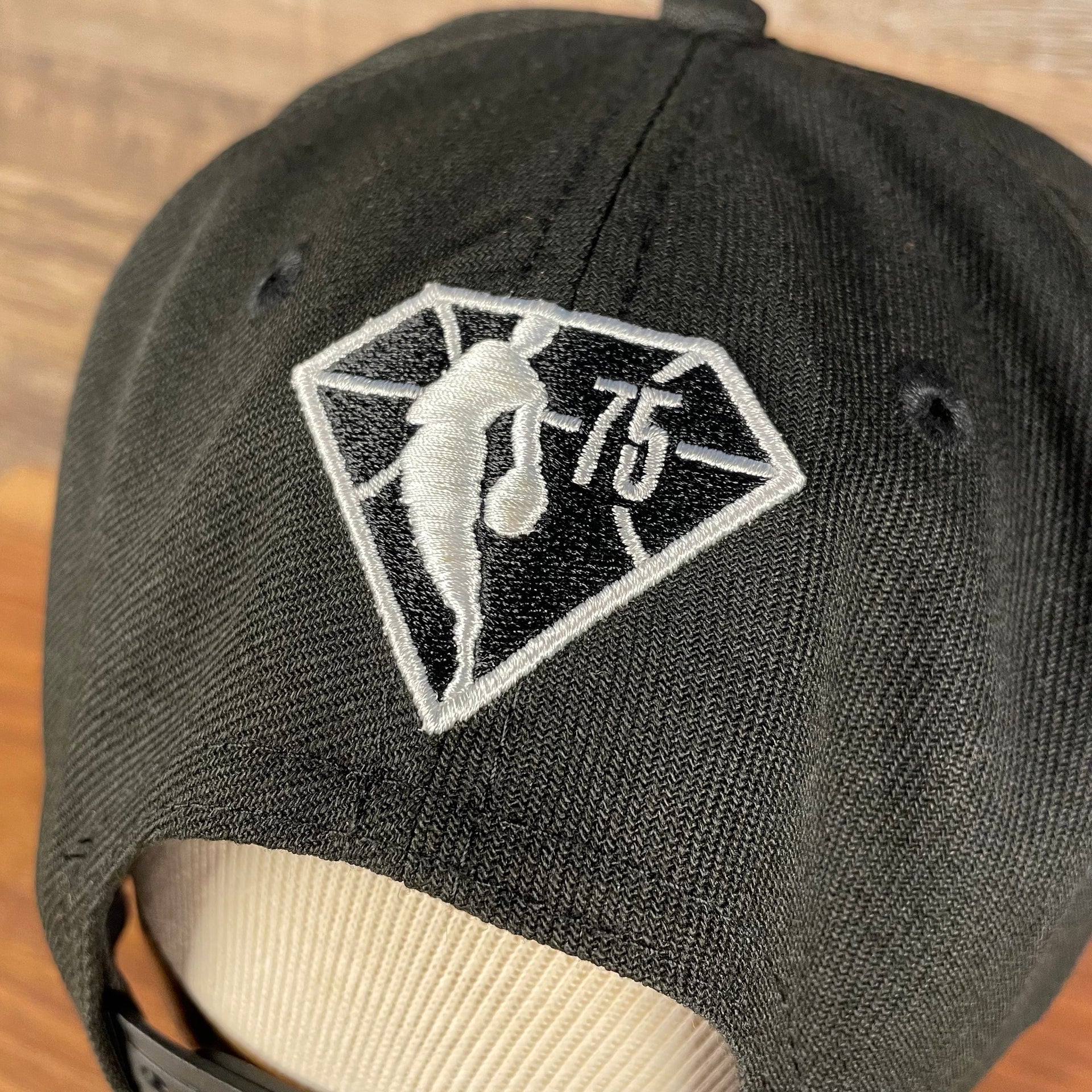Close up of the NBA 75th Anniversary logo on the back of the Brooklyn Nets NBA 75th Anniversary 2012 Side Patch Gray Bottom Black 9Fifty Snapback Hat | City Edition