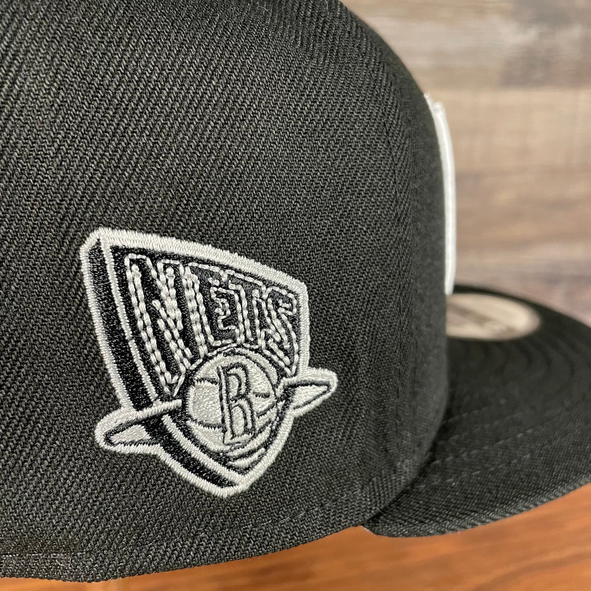 Close up of the retro 2012 side patch logo on the Brooklyn Nets NBA 75th Anniversary 2012 Side Patch Gray Bottom Black 9Fifty Snapback Hat | City Edition