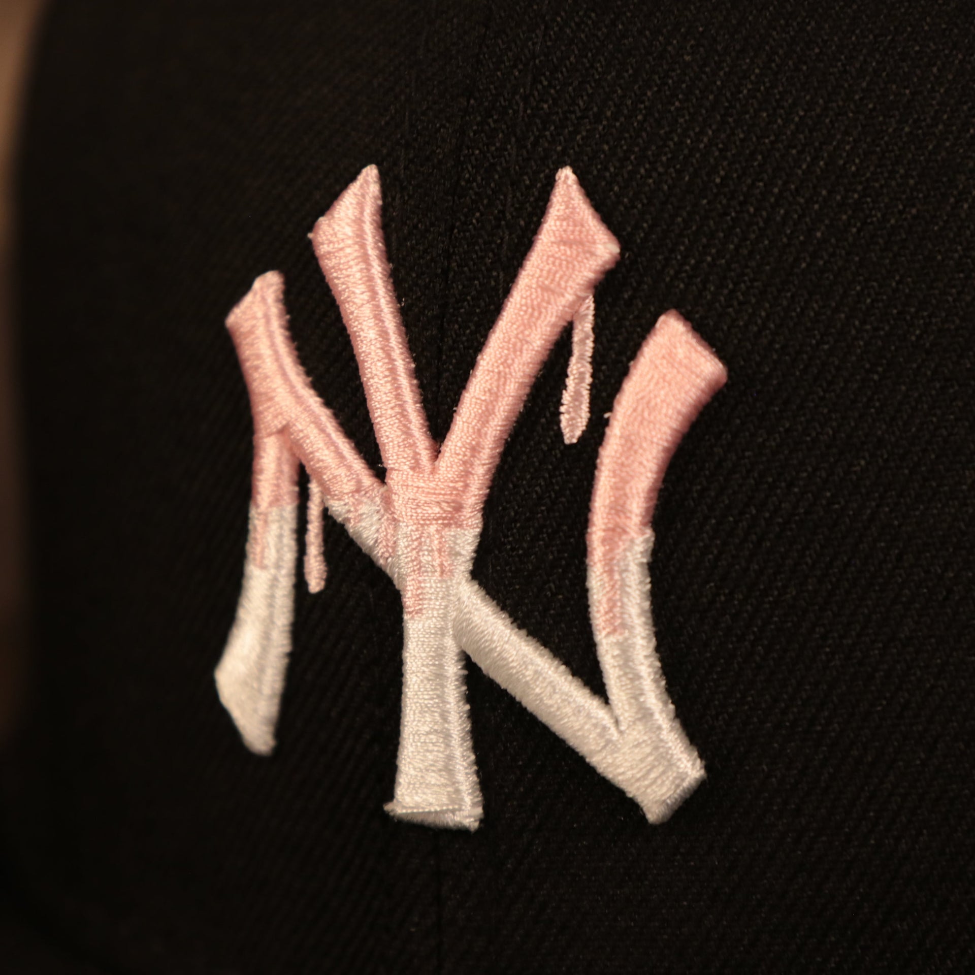 Close up of the Yankees logo on the front of the New York Yankees 1996 World Series Side Patch Drip Logo Pink Bottom 9Fifty Snapback Hat