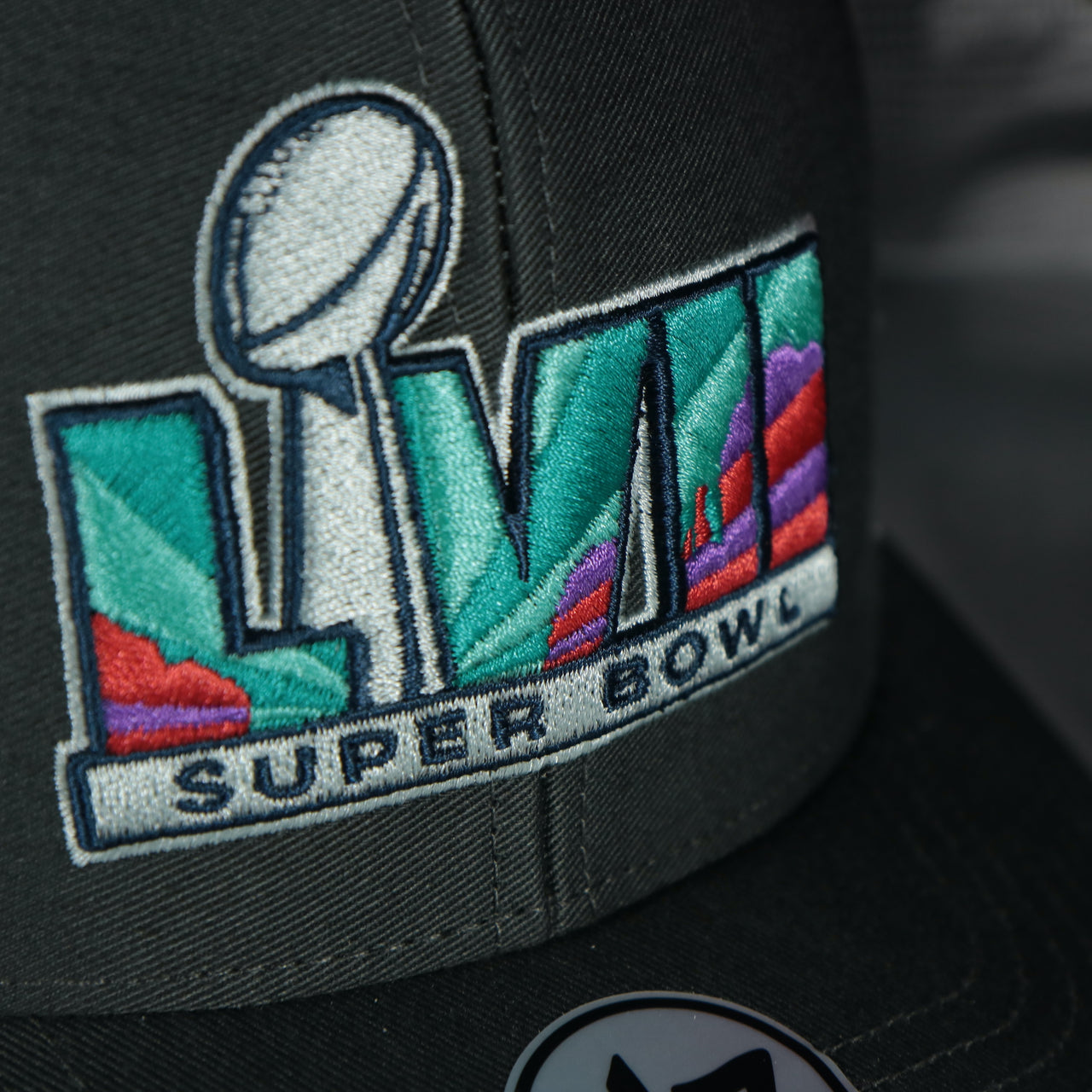 Close up of the front Super Bowl LVII logo on the Philadelphia Eagles Super Bowl LVII (Super Bowl 57) Side Patch Charcoal/White Trucker Hat