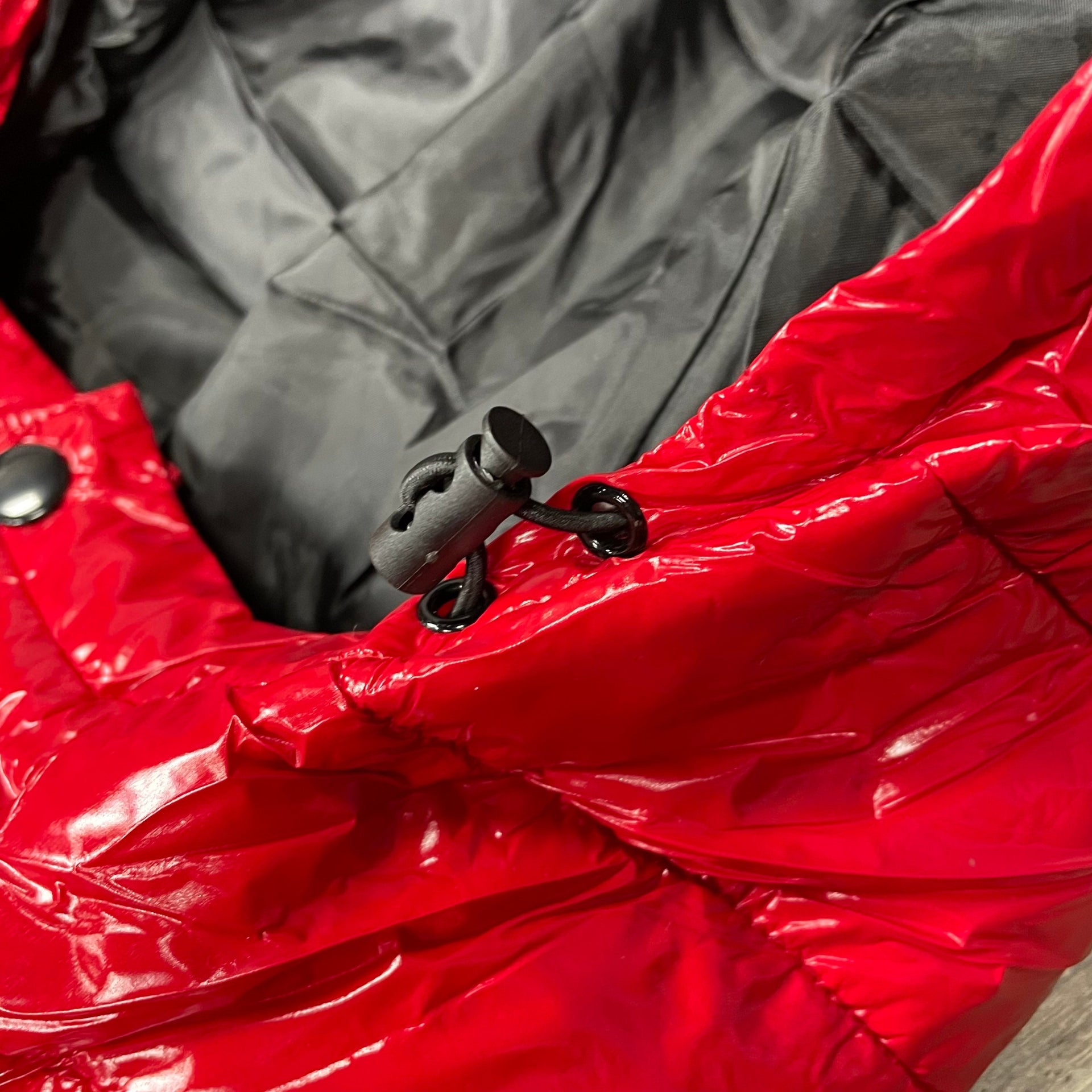 Close up of the hood adjustment on the Glossy Metallic Shiny Men’s Puffer Jacket with Removable Hood | Red/Black