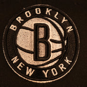 Close up of the Brooklyn Nets logo of the Brooklyn Nets "City Cluster" Side Patch Gray Bottom Black 59Fifty Fitted Cap