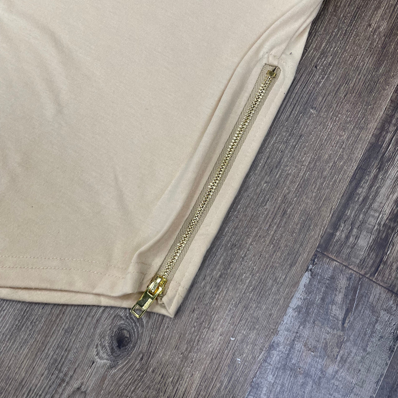 Close up of the gold metallic side zipper on the Scallop Hem Curved Bottom Long Fit Extended Men's Streetwear T-Shirt with Side Zippers | Pastel Khaki