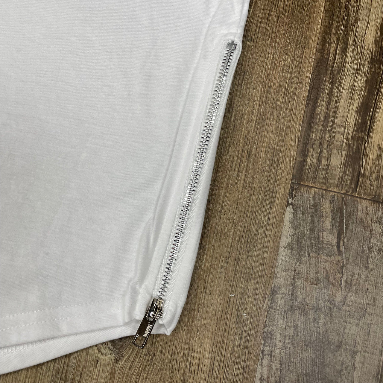 Close up of the zipper on the Scallop Hem Curved Bottom Long Fit Extended Men's Streetwear T-Shirt with Side Zippers | White