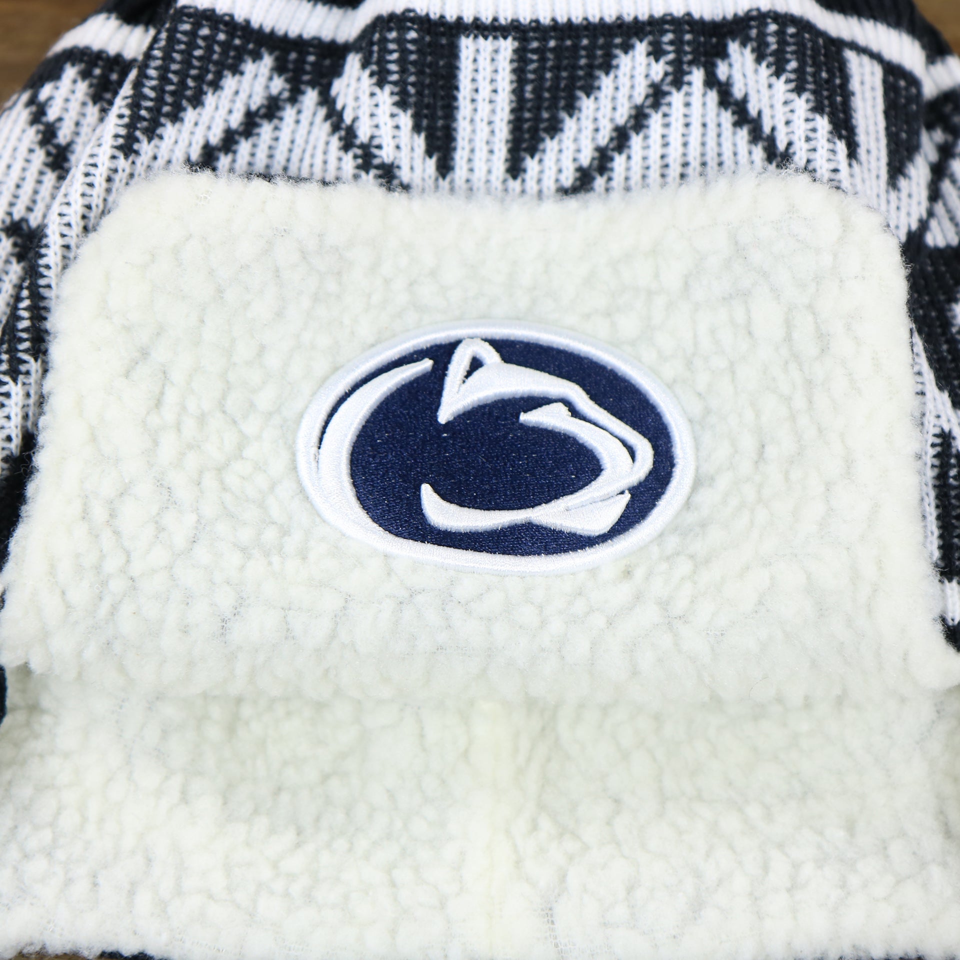 The Nittany Lions Logo on the Penn State Nittany Lions Winter Print Trapper Hat | Navy Blue Trapper Hat
