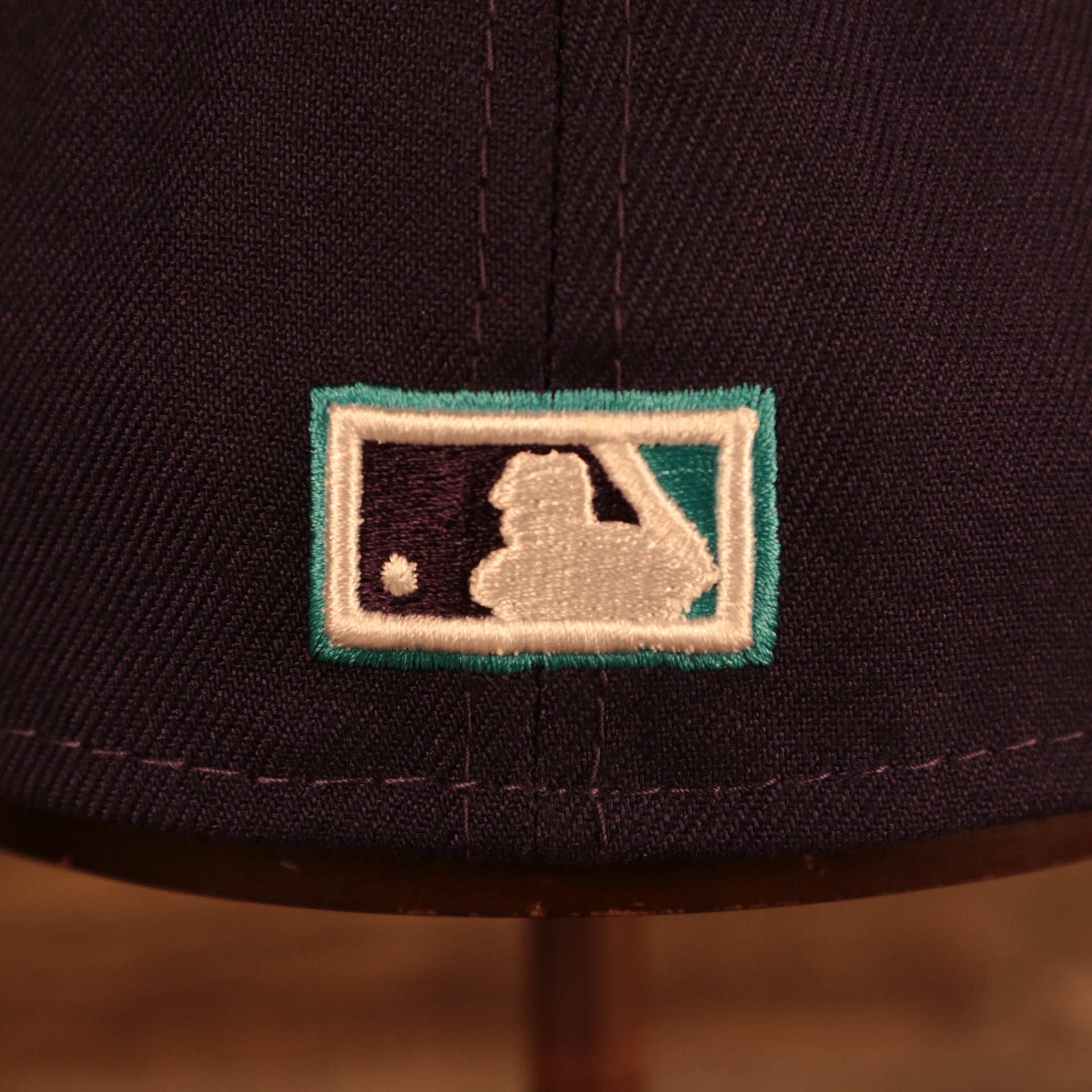 Close up of the cooperstown batterman logo on the back of the Arizona Diamondbacks "City Cluster" Side Patch Gray Bottom Purple 59Fifty Fitted Cap