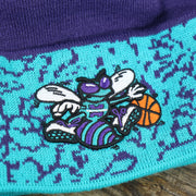 The Charlotte Hornets Logo on the Retro Charlotte Hornets Cuffed Chaos Pom Pom Beanie | Purple And Light Blue Winter Beanie
