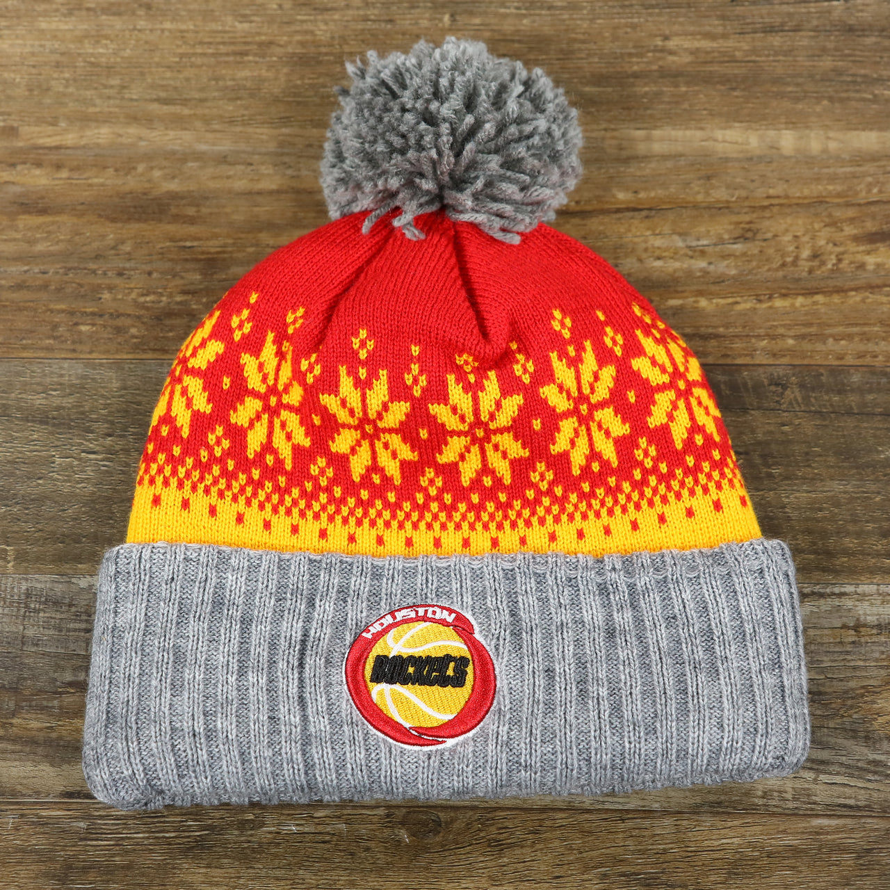 The front of the Retro Houston Rockets Arctic Snowflake Ugly Sweater Pattern Cuffed Beanie With Pom Pom | Yellow, Maroon, and Gray Winter Beanie
