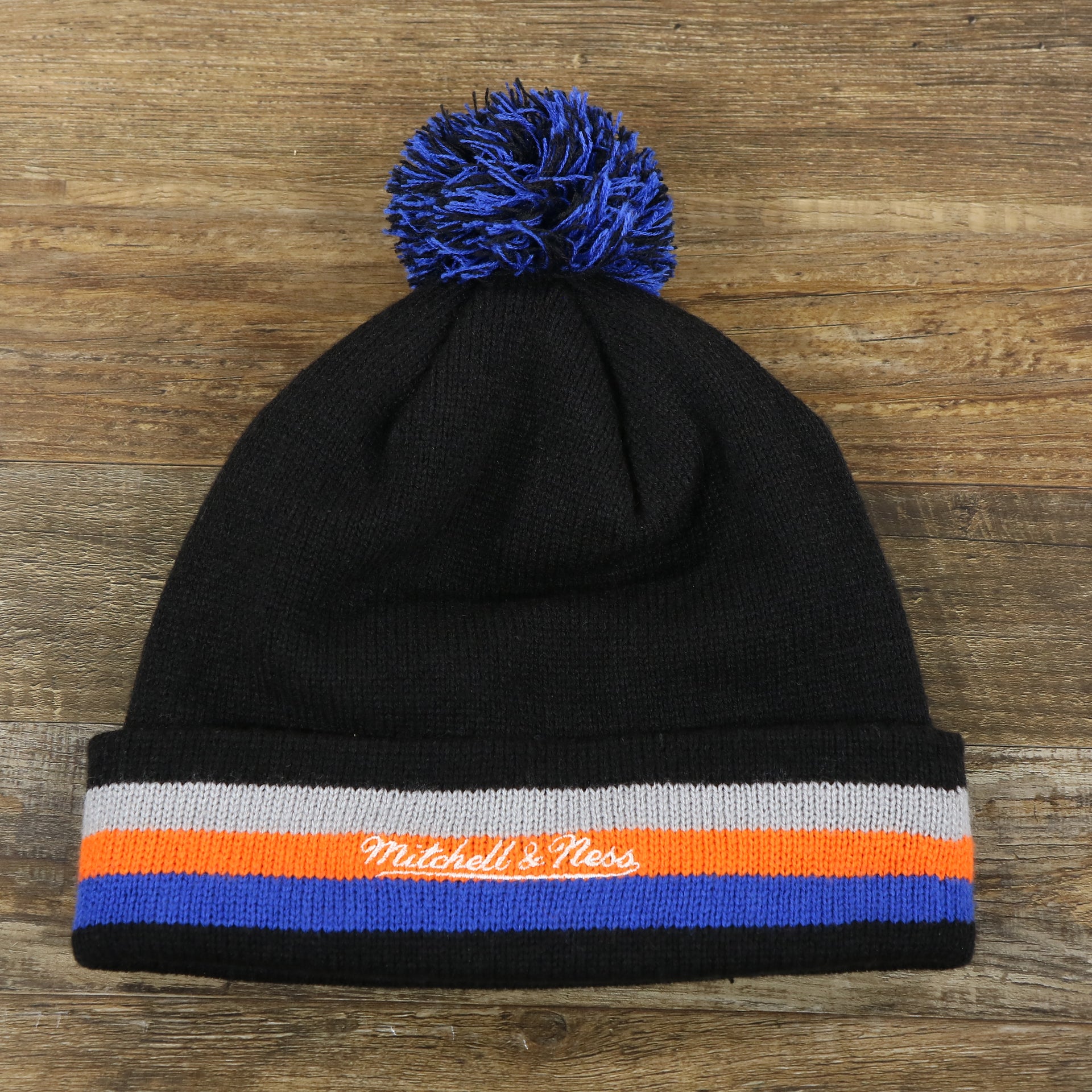 The backside of the New York Knicks Striped Cuff Black Out Blackout Knit WInter Beanie With Multi Colored Pom Pom | Black Winter Beanie