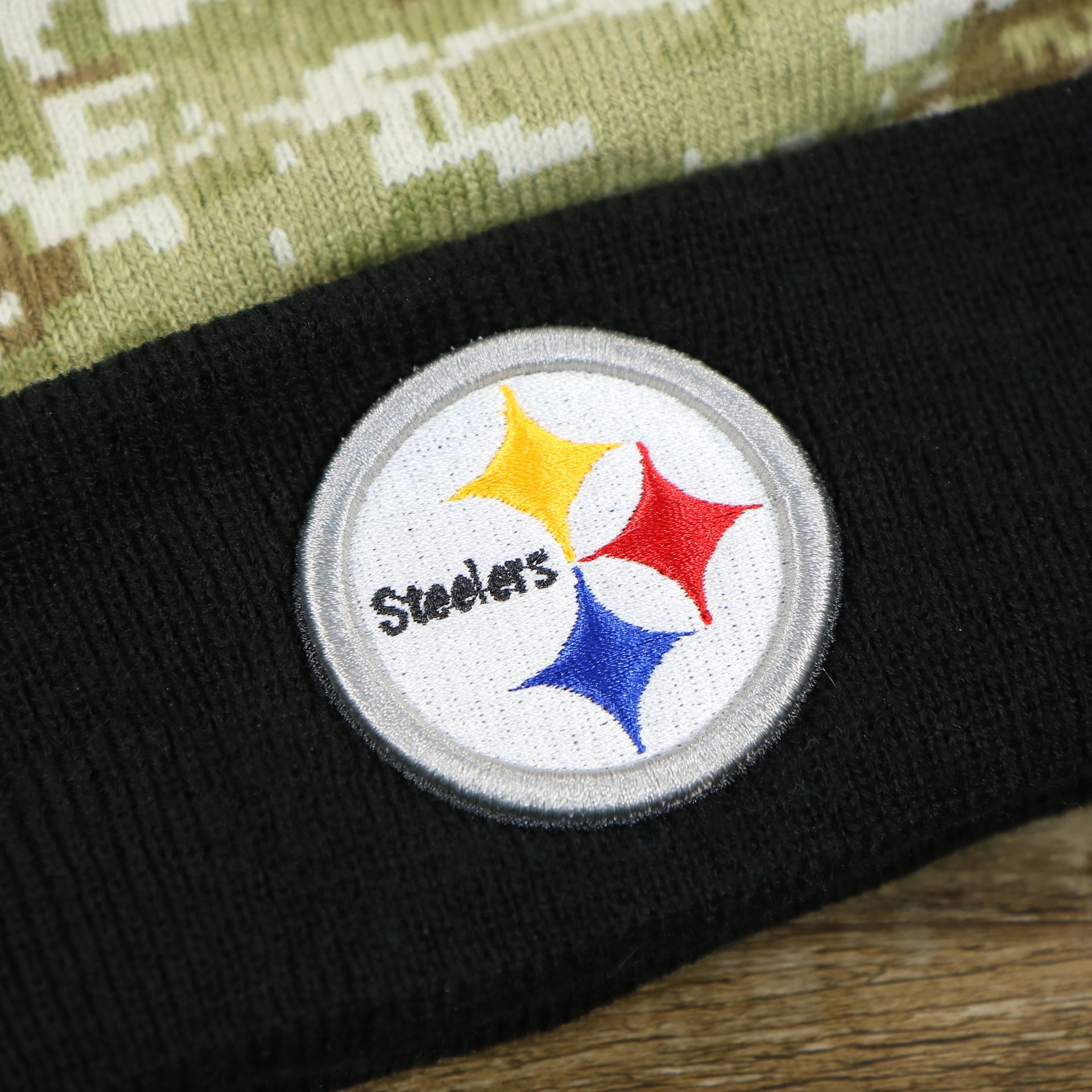 The Steelers Logo on the Pittsburgh Steelers NFL Salute To Service Cuffed Winter Beanie | Camo and Black Beanie