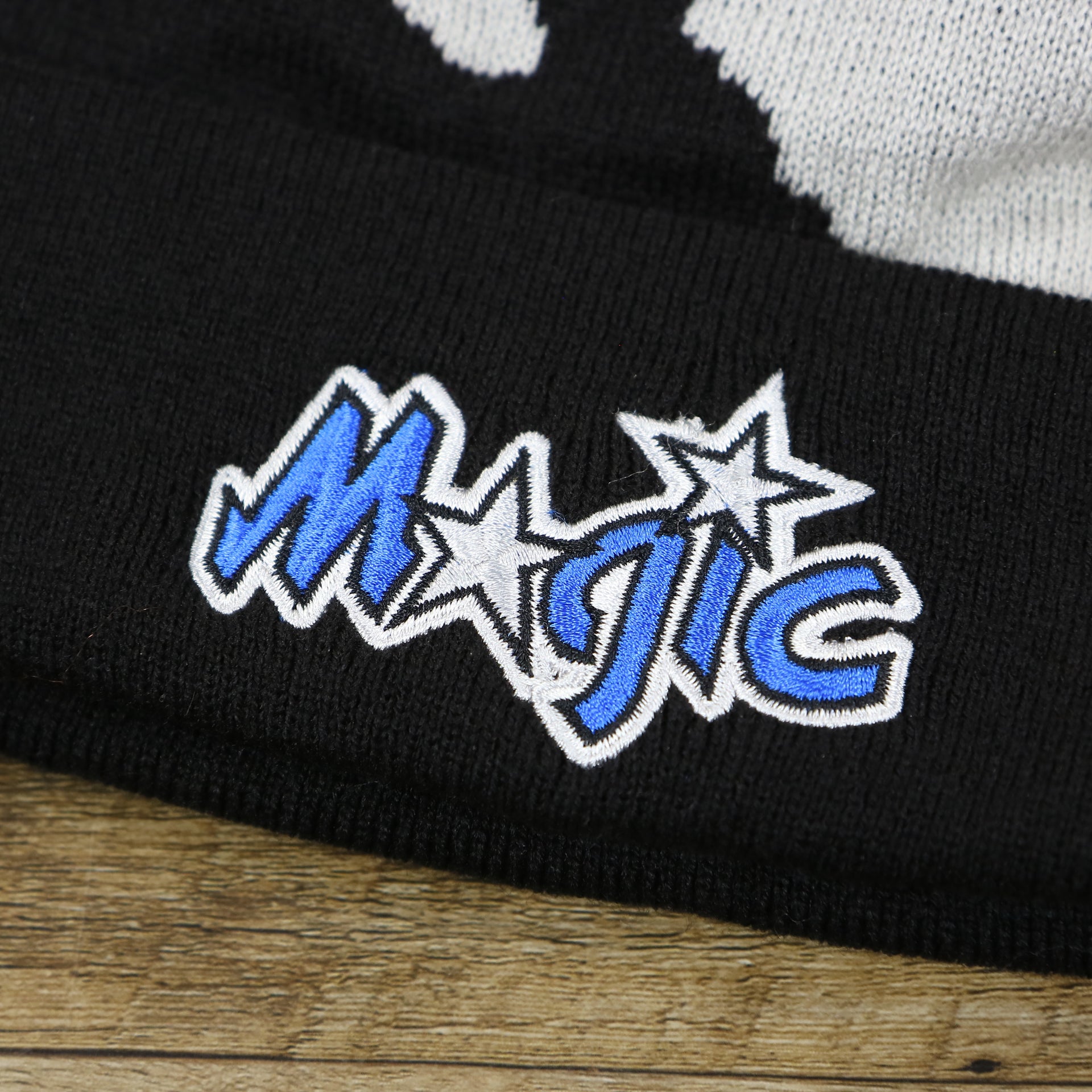 The Magic Logo on the Orlando Magics Paint Brush Cuffed Winter Beanie With Pom Pom | Black, Gray, And Blue Winter Beanie