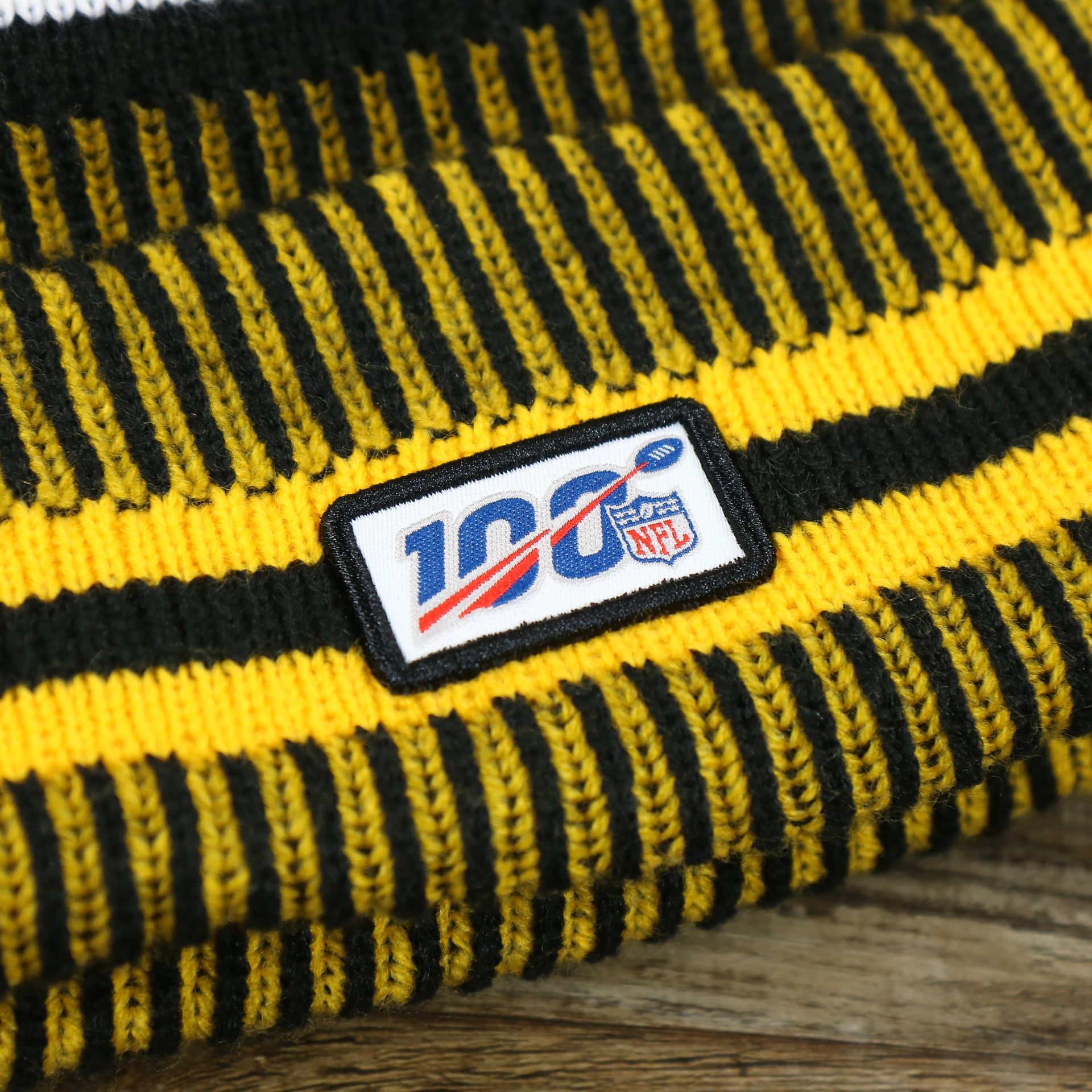 The NFL 100 Logo on the Pittsburgh Steelers On Field Sideline Cuffed Winter Knit Pom Pom Beanie | Yellow Winter Beanie