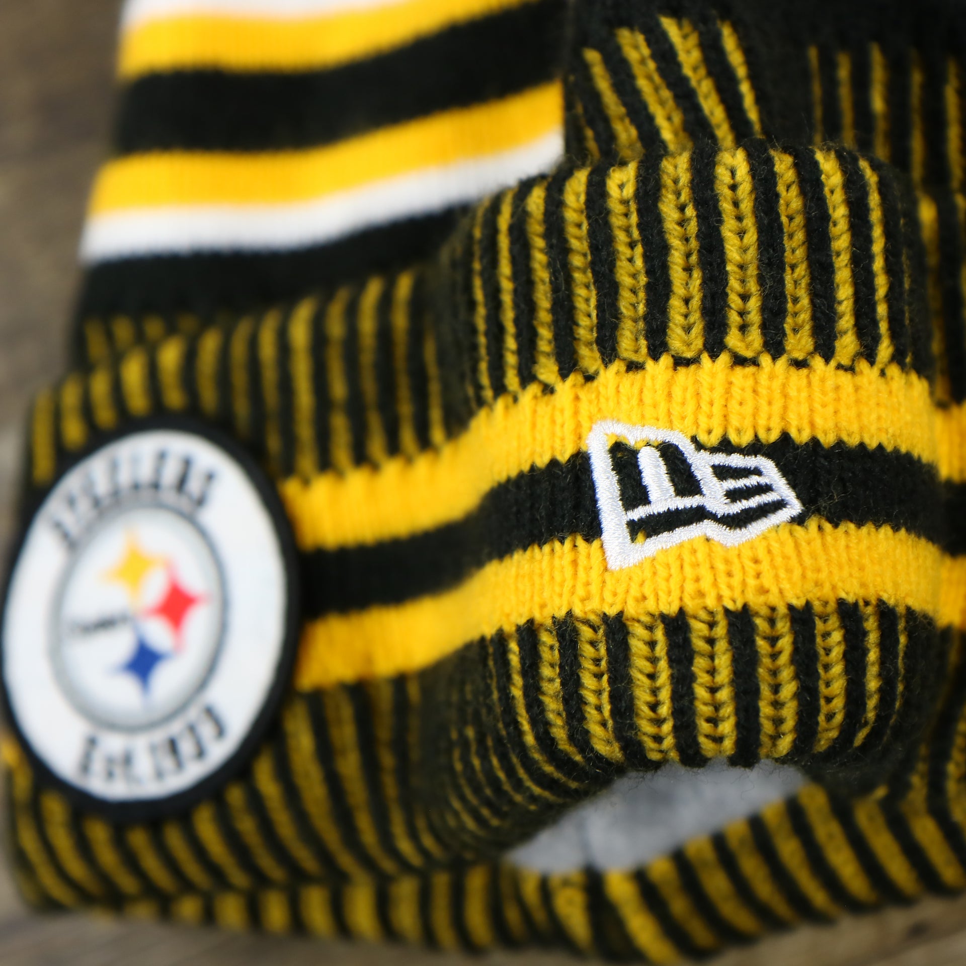 The New Era Logo on the Pittsburgh Steelers On Field Sideline Cuffed Winter Knit Pom Pom Beanie | Yellow Winter Beanie