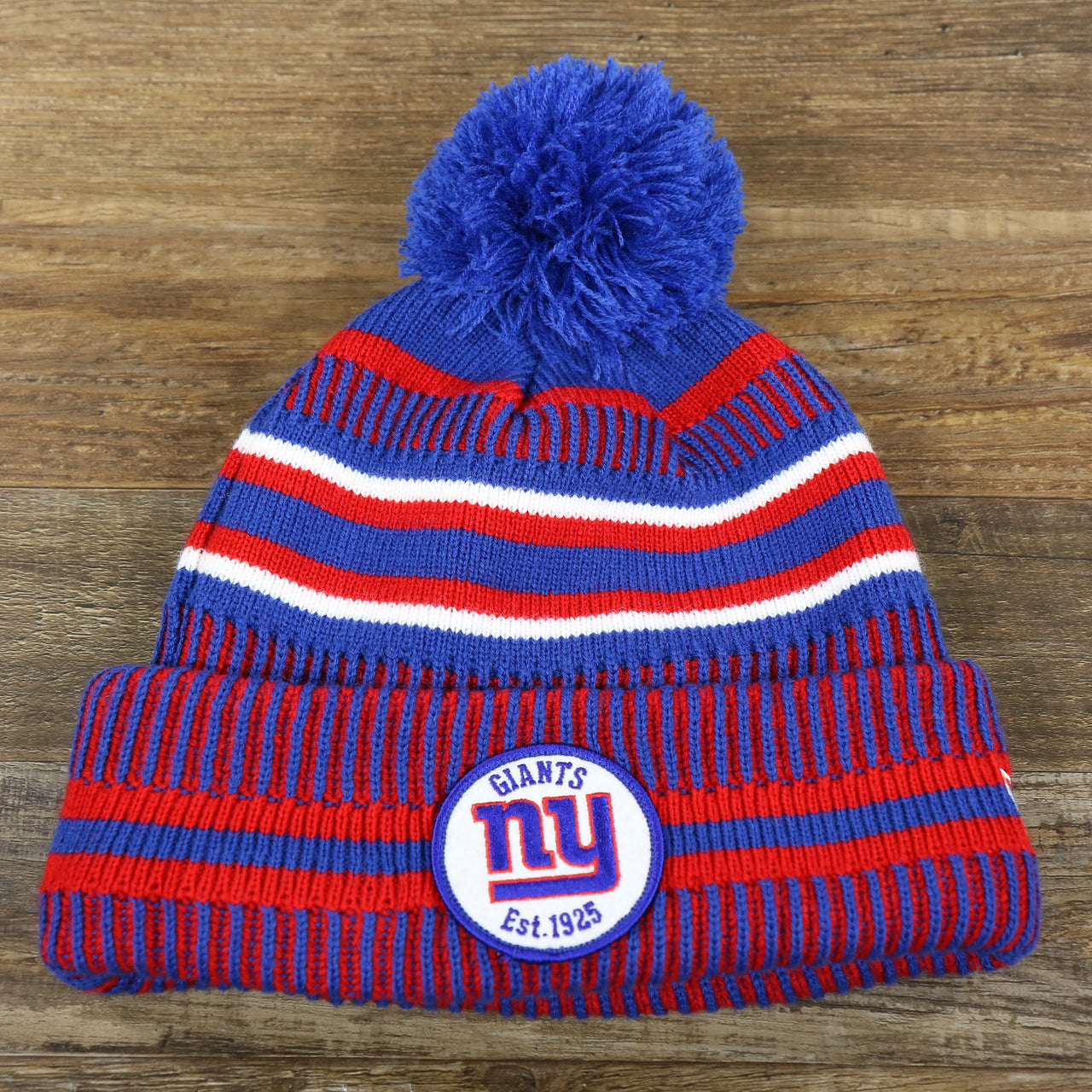 The front of the New York Giants On Field Sideline Cuffed Winter Knit Pom Pom Beanie | Red Winter Beanie
