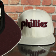 maroon under visor on the Philadelphia Phillies Cooperstown 1970 "Phillies" Script 1984 Phillies logo side patch Cream Snapback Hat