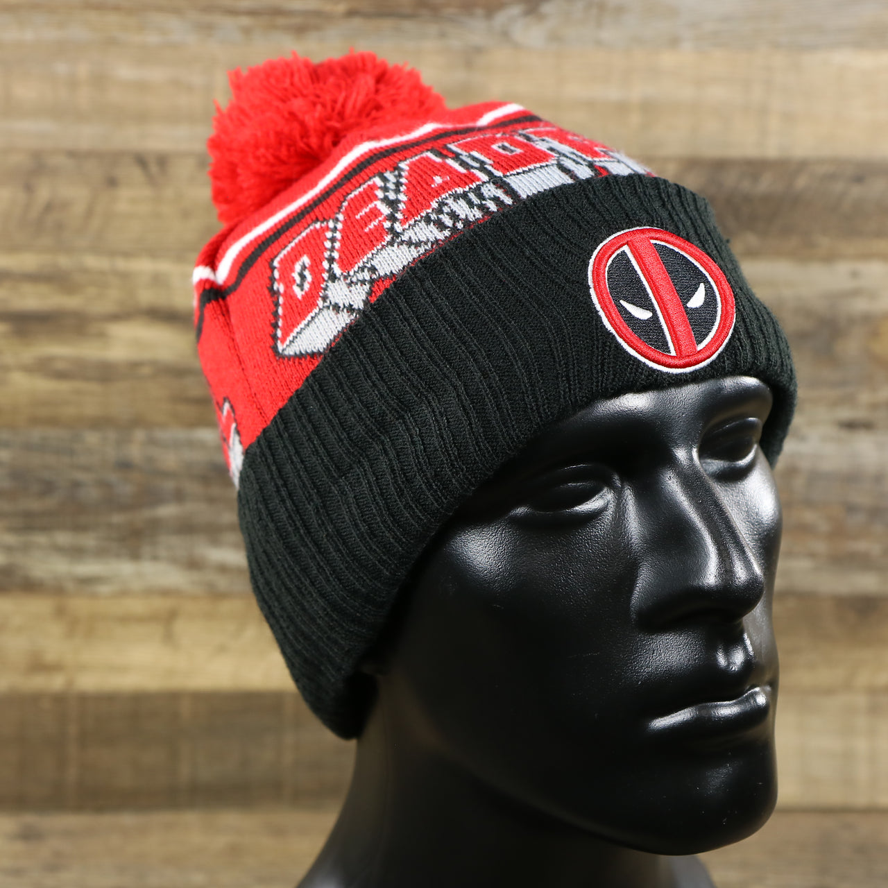 The DC Comics Deadpool Mask Logo Deadpool Wordmark Striped Beanie With Red Pom Pom | Red And Black Winter Beanie