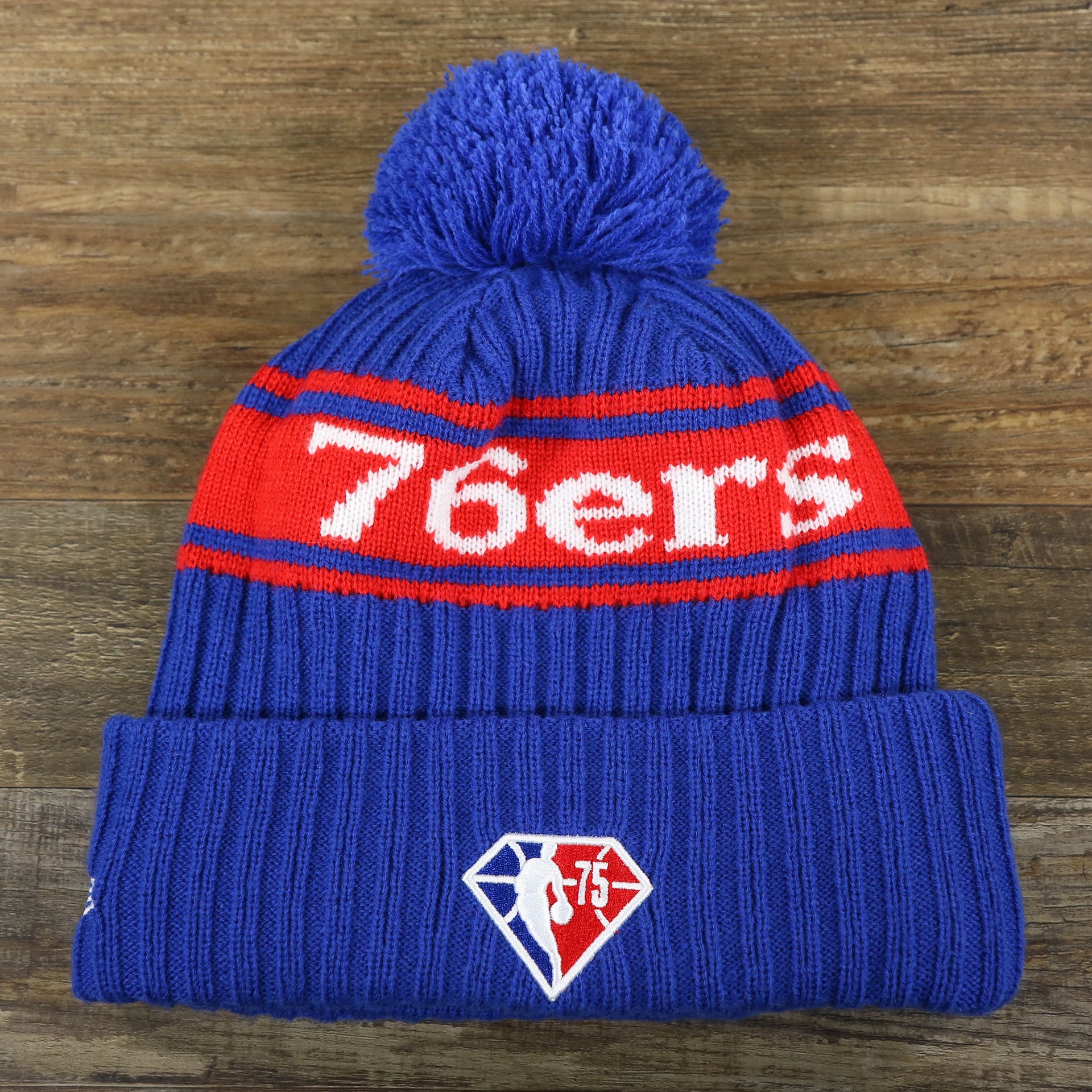 The backside of the Philadelphia 76ers Knit Wordmark Phila Arch Lettering Join Or Die Snake NBA Draft Striped Beanie | Royal Blue and Red Beanie