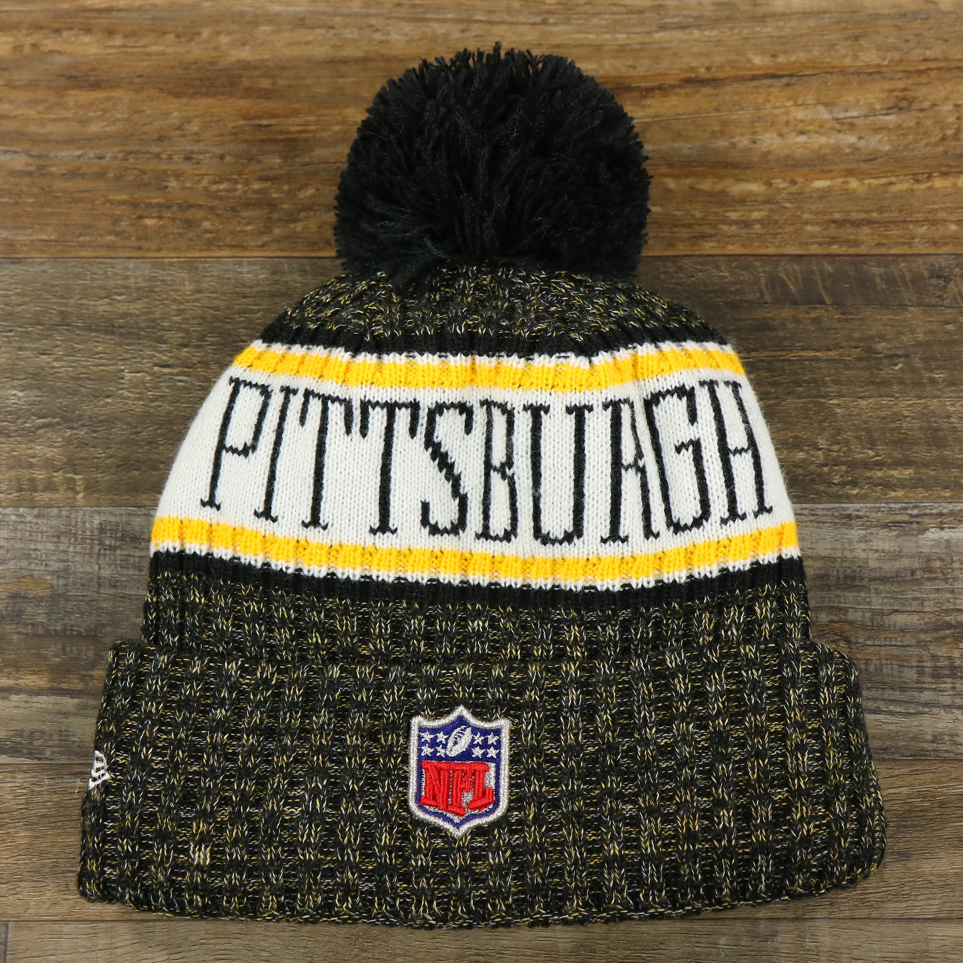 The backside of the Pittsburgh Steelers On Field Cold Weather Striped Wordmark Pom Pom Winter Beanie | Black and Yellow Beanie