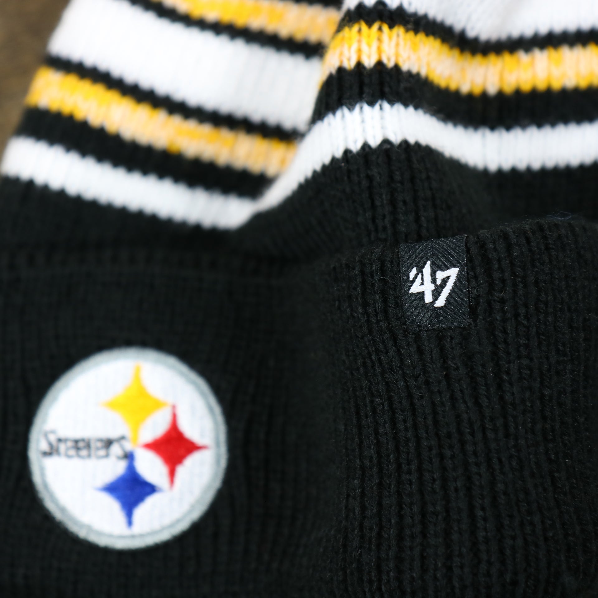The 47 Brand Tag on the Kid’s Pittsburgh Steelers Striped Pom Pom Winter Beanie | Black, Yellow, And White Beanie