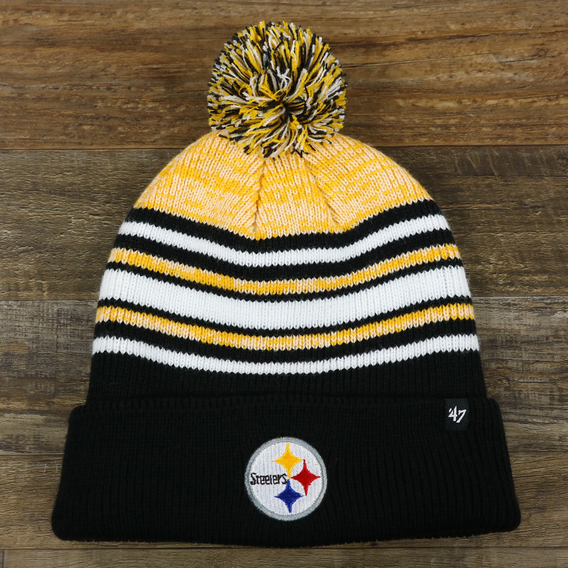 The front of the Kid’s Pittsburgh Steelers Striped Pom Pom Winter Beanie | Black, Yellow, And White Beanie