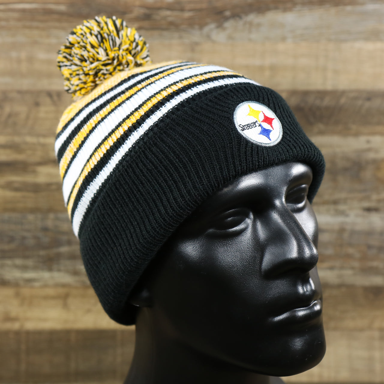 The Kid’s Pittsburgh Steelers Striped Pom Pom Winter Beanie | Black, Yellow, And White Beanie on a doll