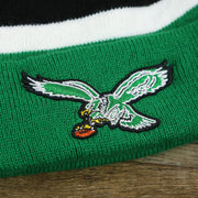 The Throwback Eagles Logo on the Legacy Philadelphia Eagles Cuffed Logo Striped Winter Beanie With Pom Pom | Kelly Green Winter Beanie