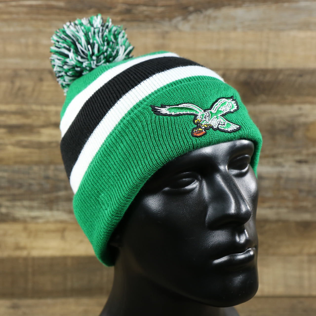 The Legacy Philadelphia Eagles Cuffed Logo Striped Winter Beanie With Pom Pom | Kelly Green Winter Beanie on a doll