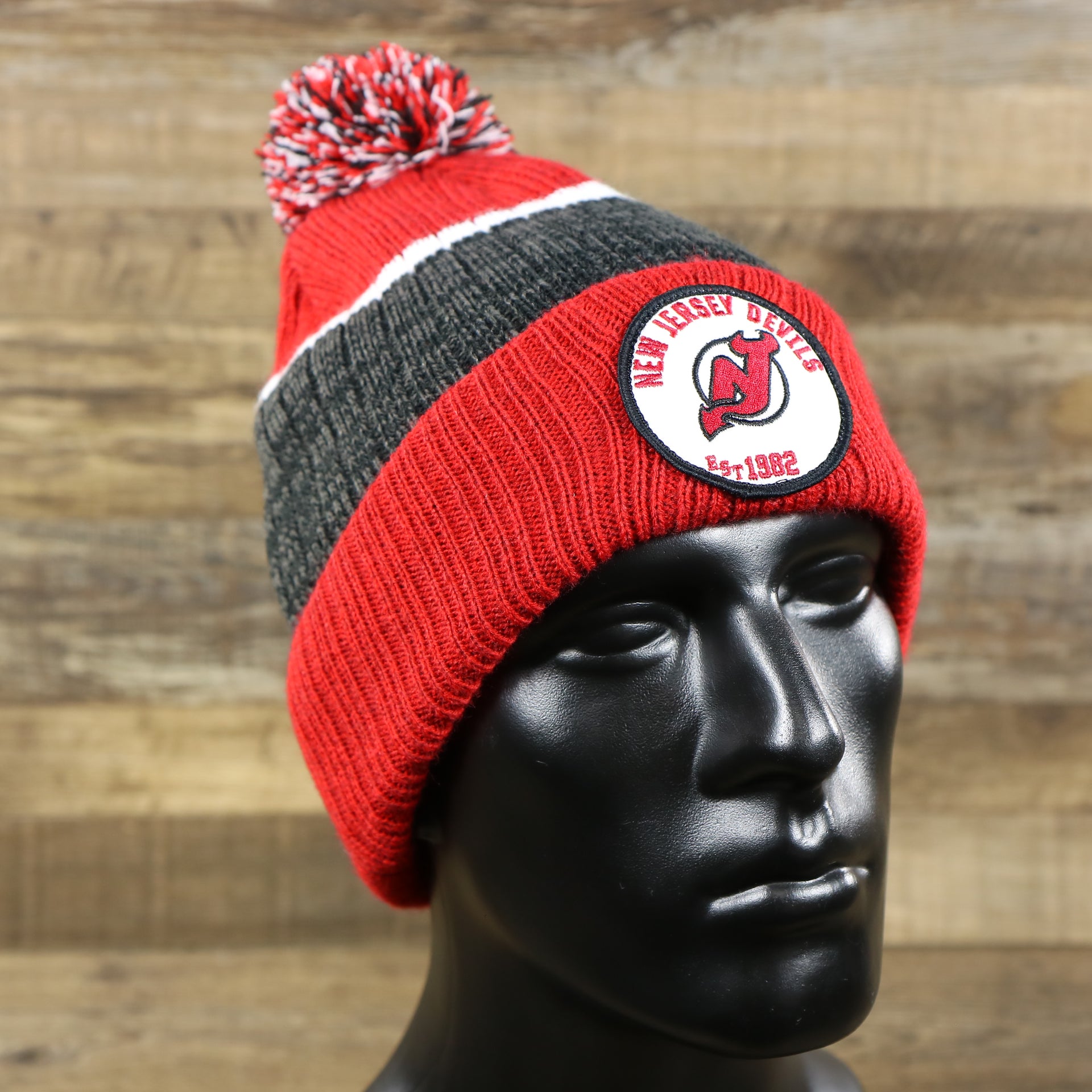 The New Jersey Devils Cuffed Logo Striped Winter Beanie With Pom Pom | Red and Gray Winter Beanie