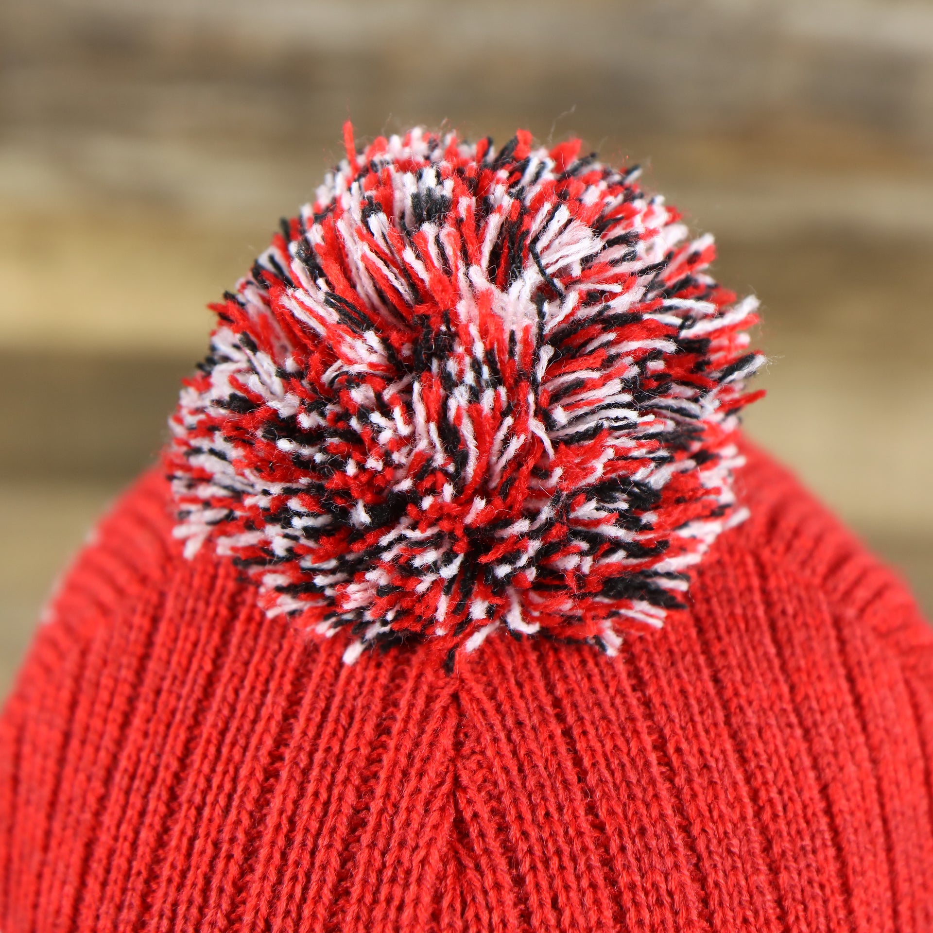 The Multi Colored Pom Pom on the New Jersey Devils Cuffed Logo Striped Winter Beanie With Pom Pom | Red and Gray Winter Beanie