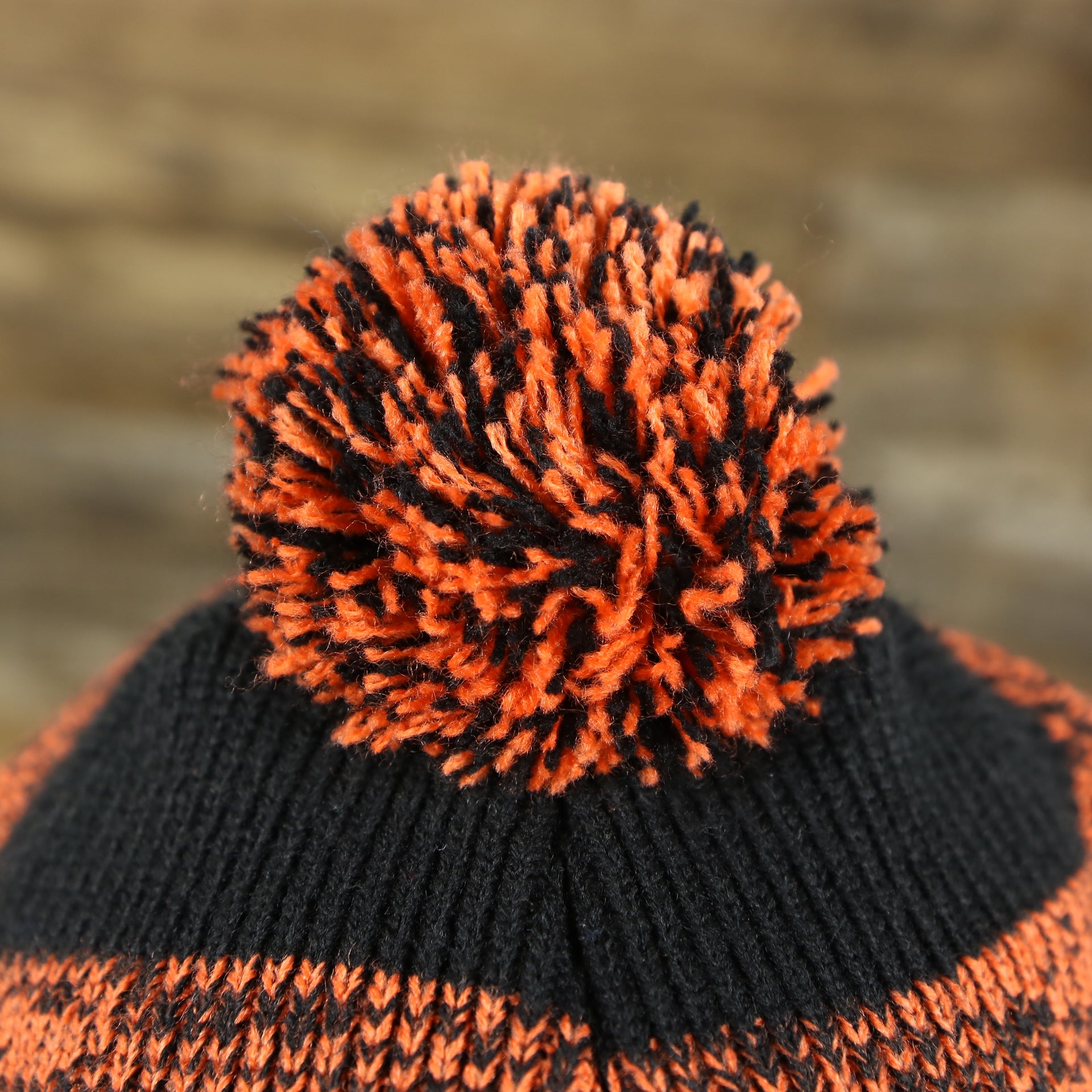 The Pom Pom on the Philadelphia Flyers Static Knit Cuffed Winter Beanie With Pom Pom | Black, Orange, And Gray Beanie