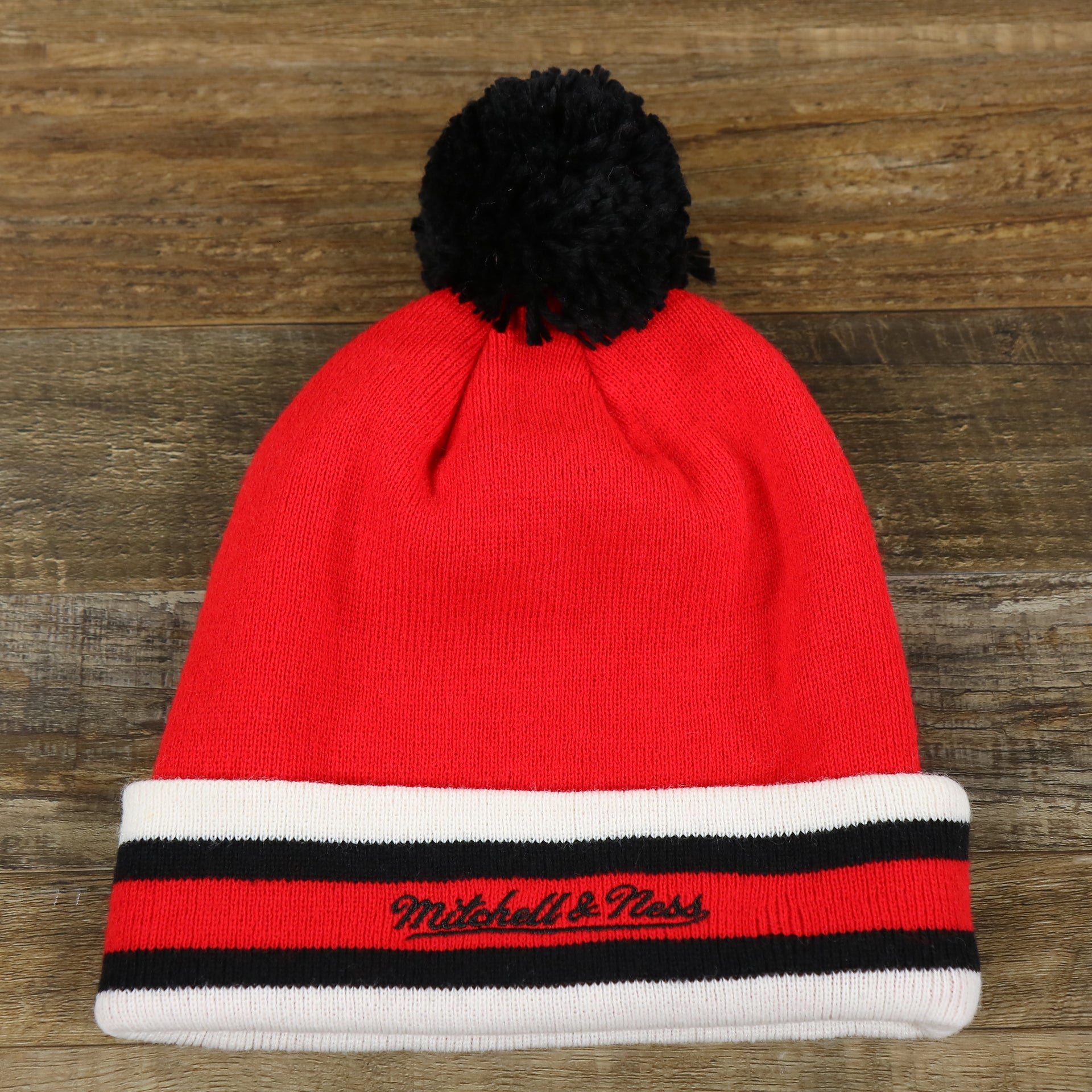 The backside of the Chicago Bulls Striped Cuff Pom Pom Winter Beanie | Red Winter Beanie