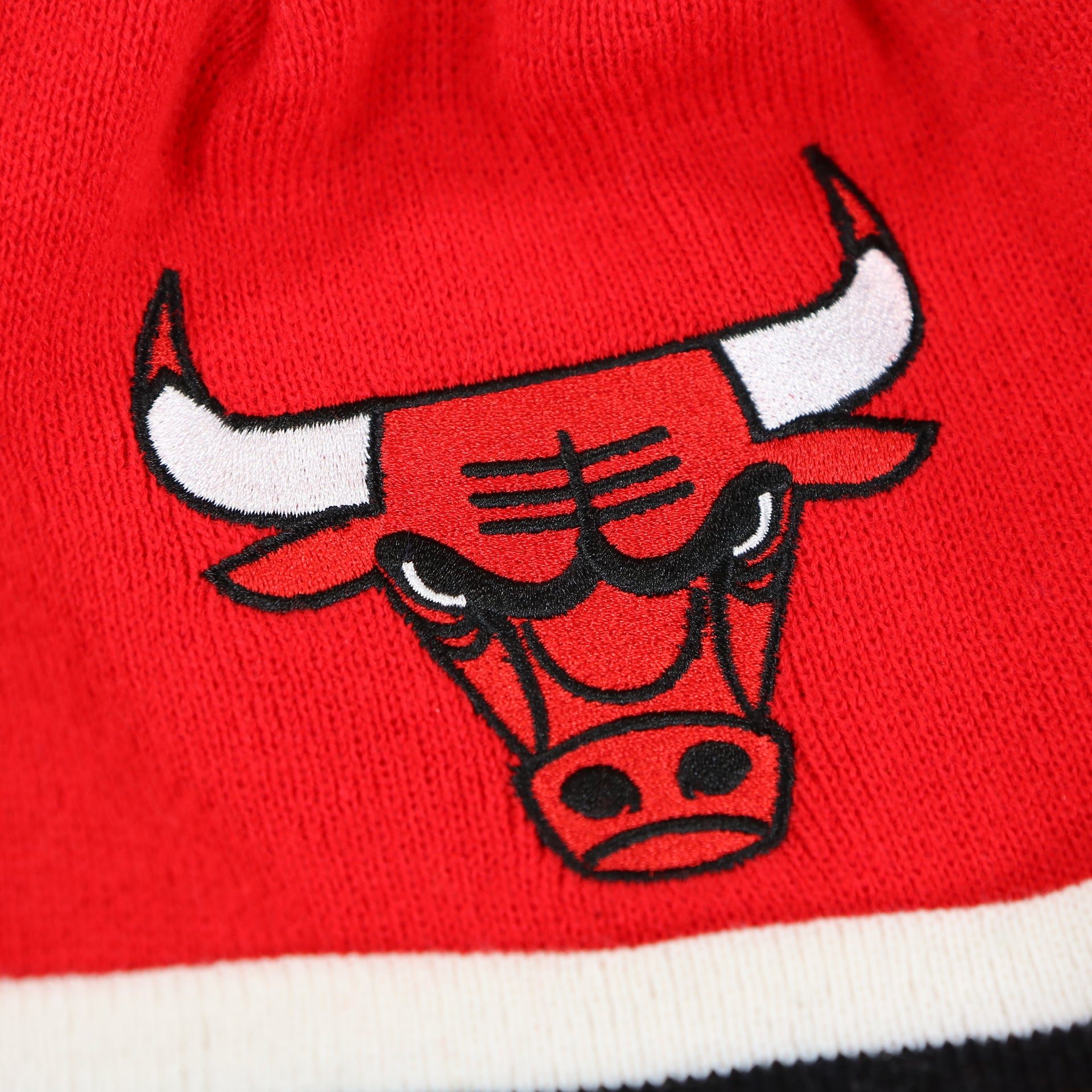 The Chicago Bulls Logo on the Chicago Bulls Striped Cuff Pom Pom Winter Beanie | Red Winter Beanie