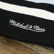 The Mitchell And Ness Script Logo on the Brooklyn Nets Cuffless Striped Winter Beanie With Pom Pom | Black, White, And Gray Beanie