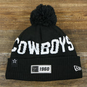 The front of the Dallas Cowboys On Field Rubber Cowboys 1960 Patch Cuffed Pom Pom Winter Beanie | Black Winter Beanie
