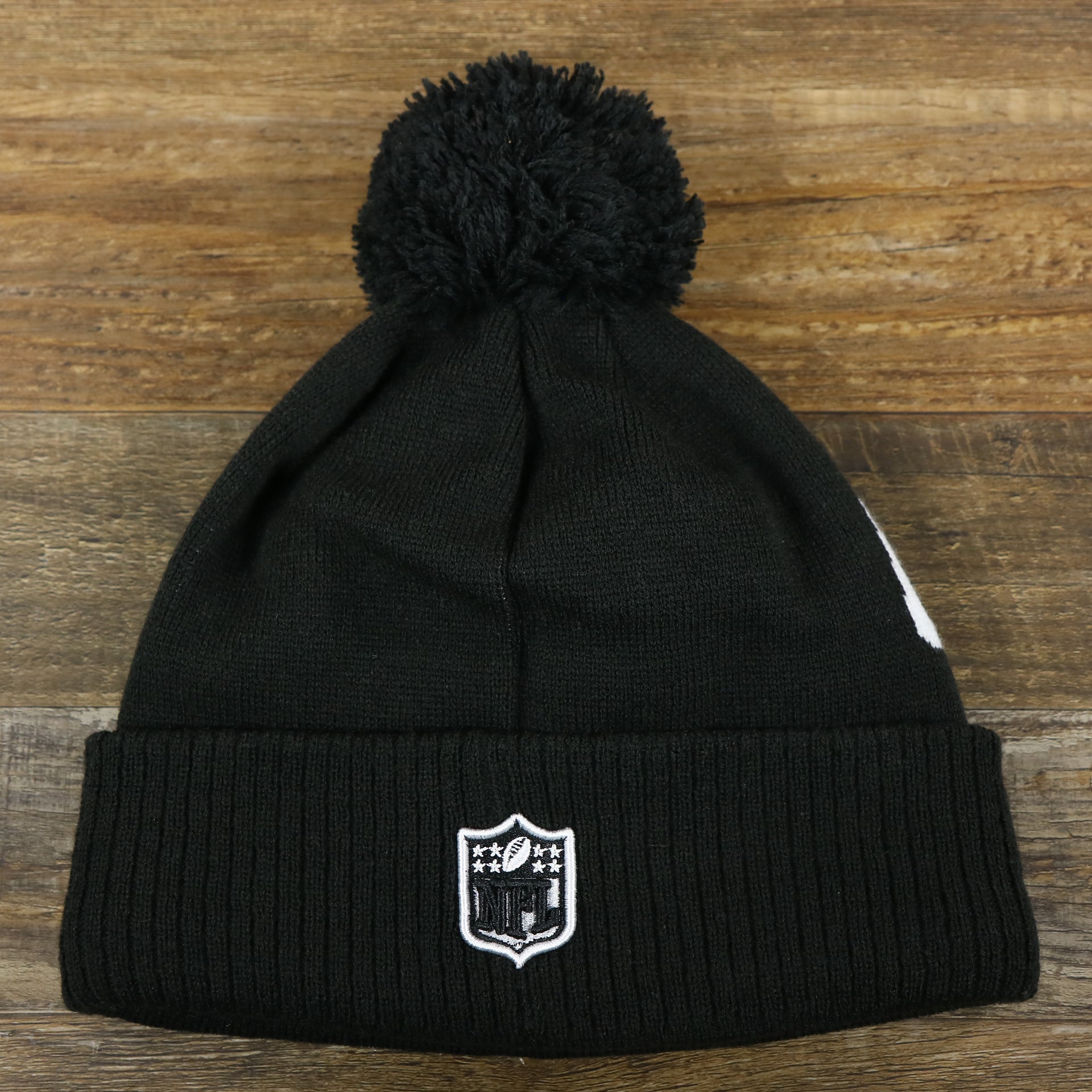 The backside of the Dallas Cowboys On Field Rubber Cowboys 1960 Patch Cuffed Pom Pom Winter Beanie | Black Winter Beanie