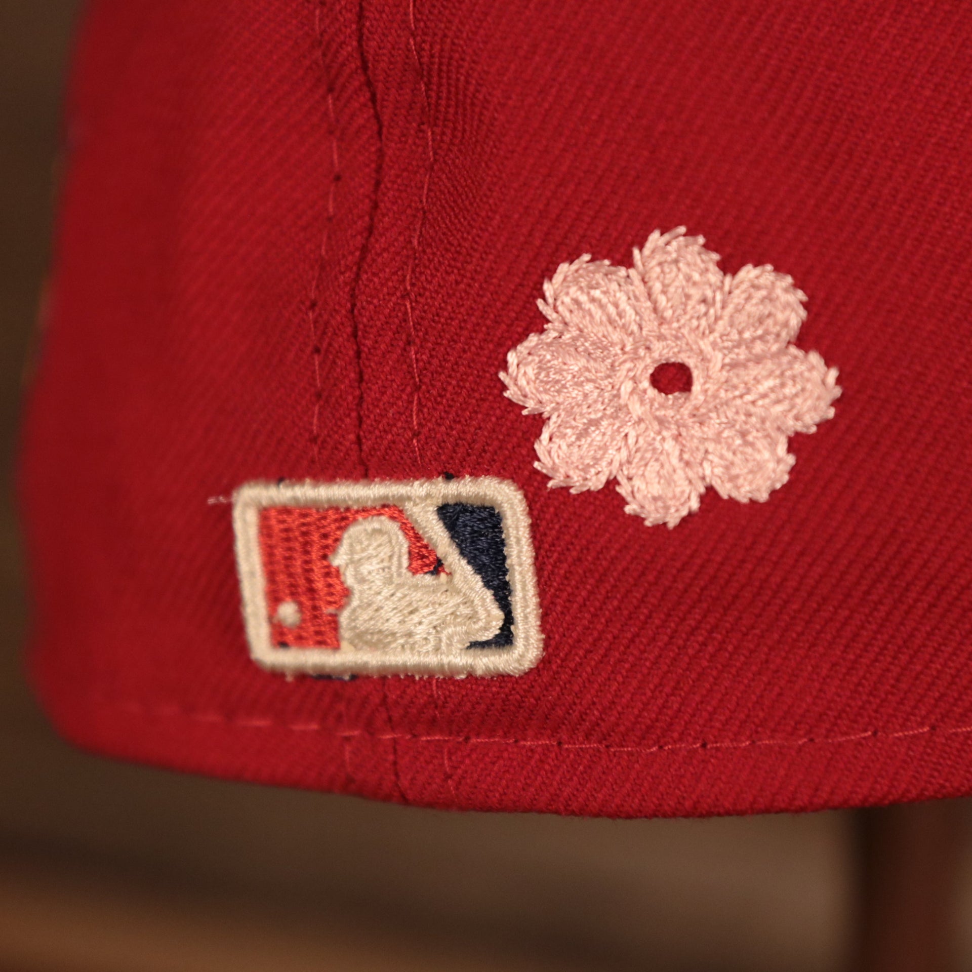 Close up of the MLB batterman logo and a crotchet flower patch on the Philadelphia Phillies All Over Floral Pattern Flower Crotchet Side Patch Pink Bottom 59Fifty Fitted Cap