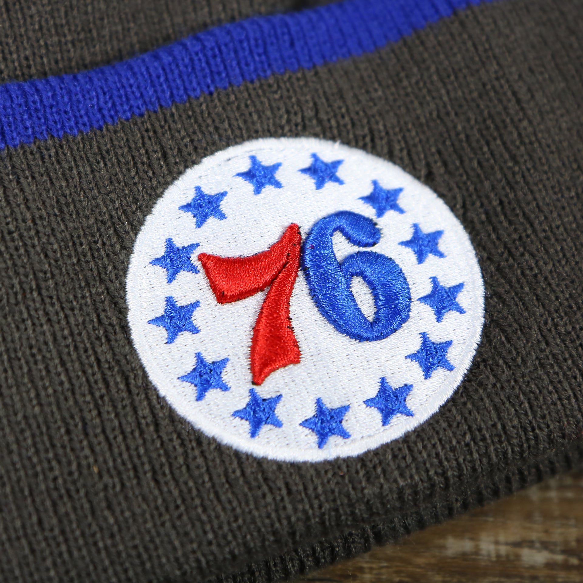 The 76ers Star Logo on the Philadelphia 76ers Cuffed Logo Baraka Knit Charcoal Winter Beanie | Gray And Royal Blue Beanie