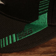 Close up of retro racing stripe with Eagles written on it, on the Philadelphia Eagles 2021 Sideline On-Field Throwback Logo 9Fifty Snapback Hat