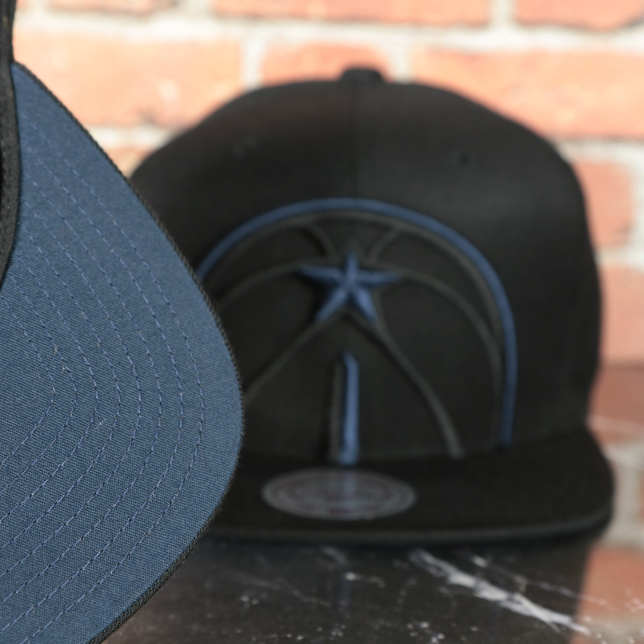 navy under visor on the Washington Wizards XL Logo Black Mitchell and Ness Snapback Hat