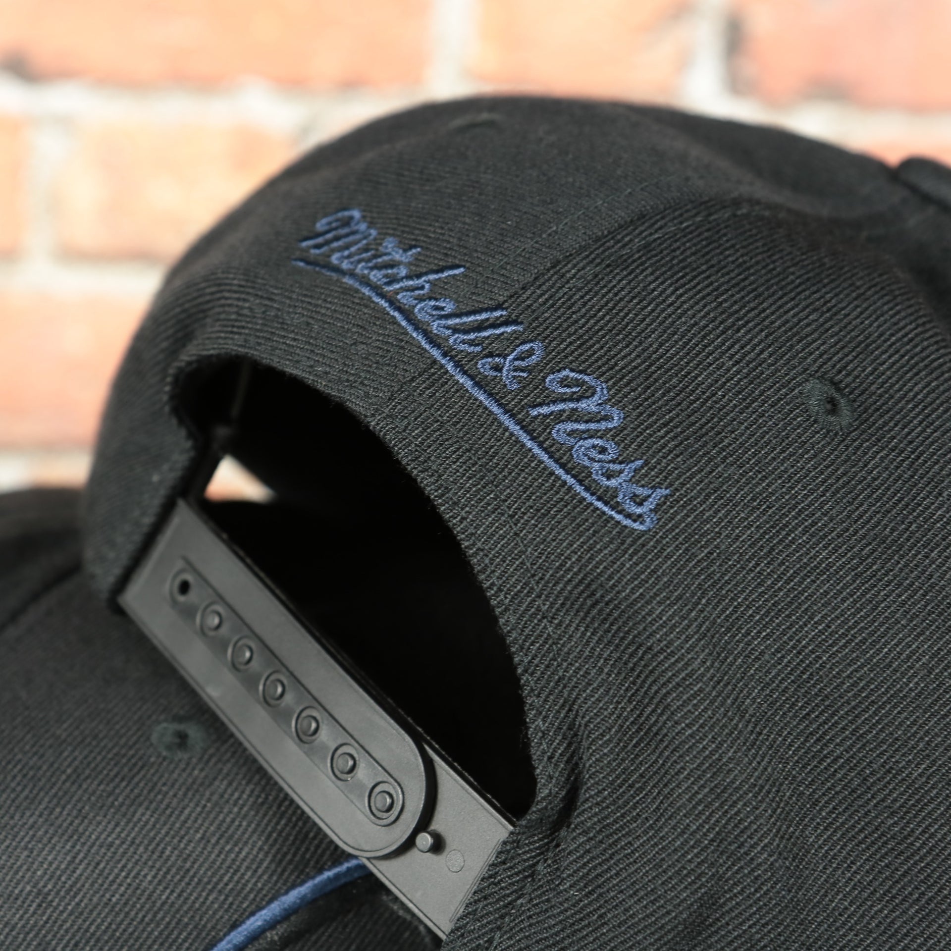 black adjustable snap on the Washington Wizards XL Logo Black Mitchell and Ness Snapback Hat