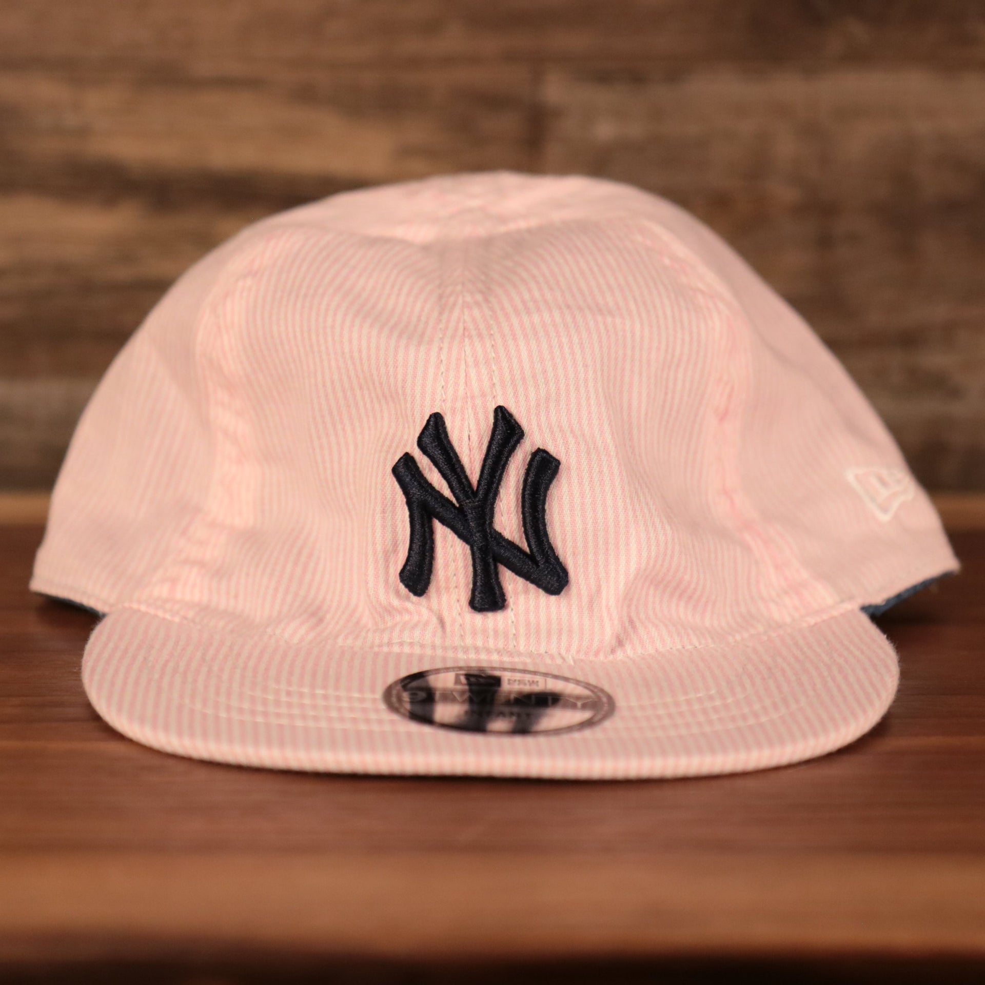 front of the New York Yankees Reversible Navy & Pink Infant 9Twenty Dad Hat