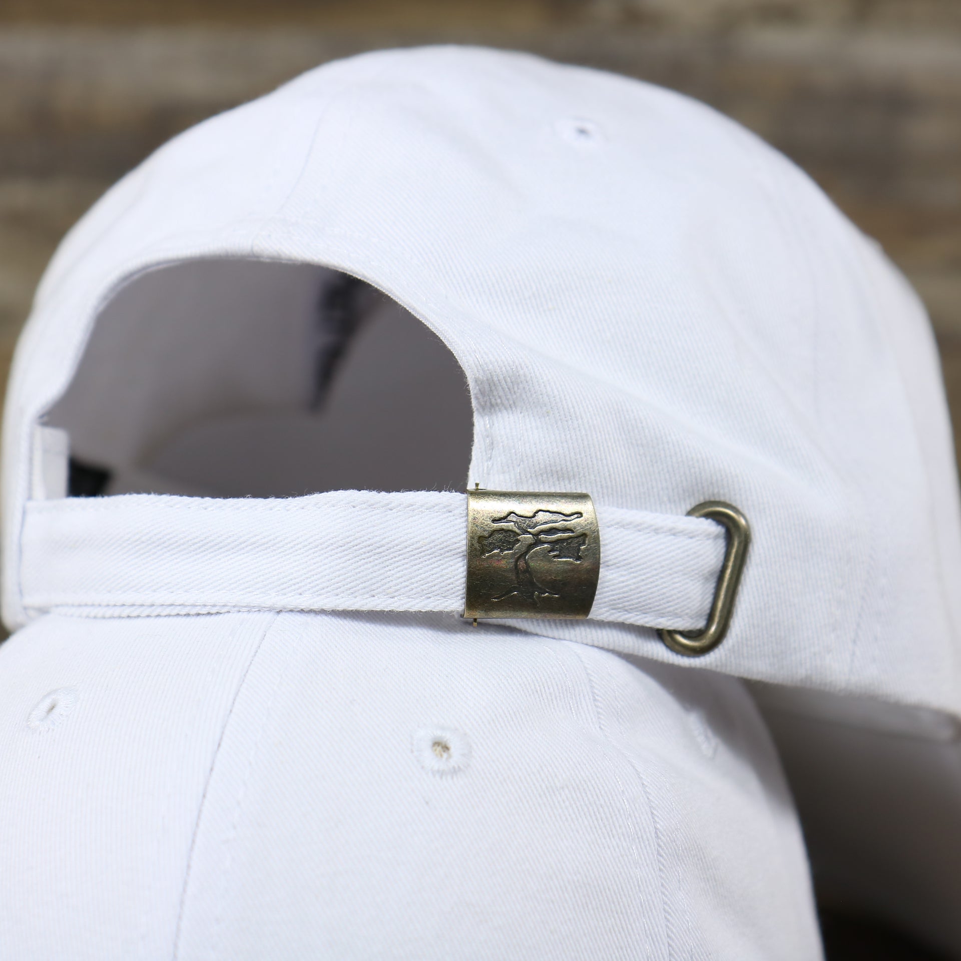 The White Adjustable Strap With Bonsai Tree Engraved Buckle on the Snow White Blank Baseball Hat | White Dad Hat